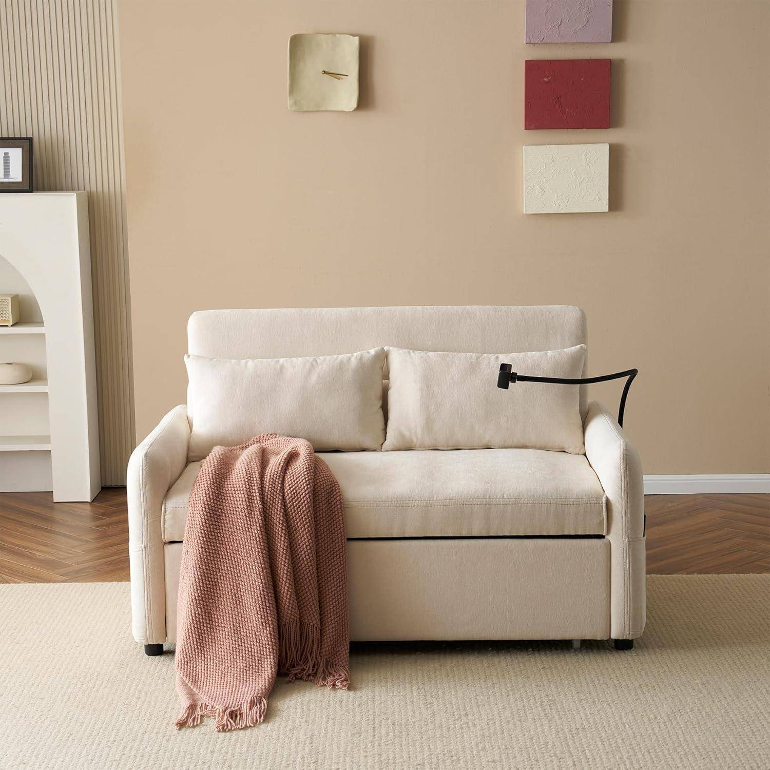 Ein beiges Sofa mit einer rosa Wurfdecke und einer schwarzen Leselampe mit Arm in einem minimalistischen Wohnzimmer mit Wandkunst und Hartholzboden.