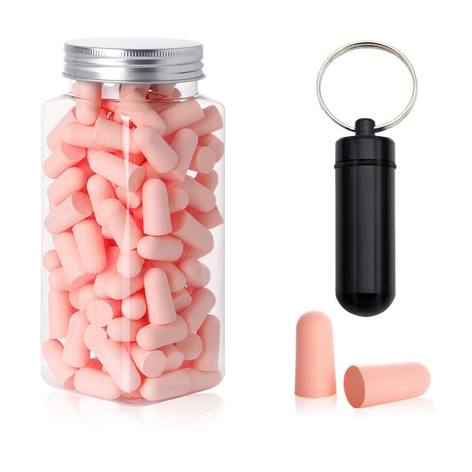 Ein Glasglas gefüllt mit rosa Schaumstoff-Ohrstöpseln sitzt neben einem schwarzen Schlüsselanhänger-Pillenförmigen Behälter und zwei losen Ohrstöpseln auf weißem Hintergrund.