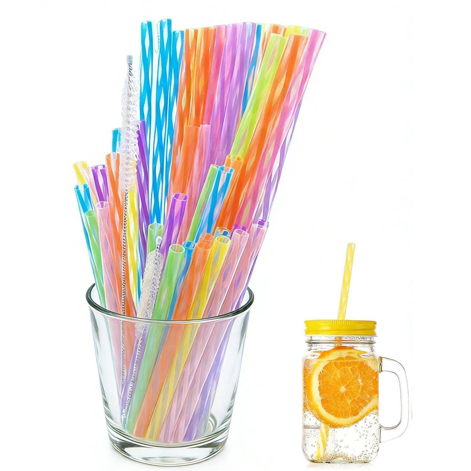 Bunte wiederverwendbare Trinkhalme in einem Glas neben einem Einmachglas mit orangenangereichertem Wasser mit gelbem Deckel und Griff.