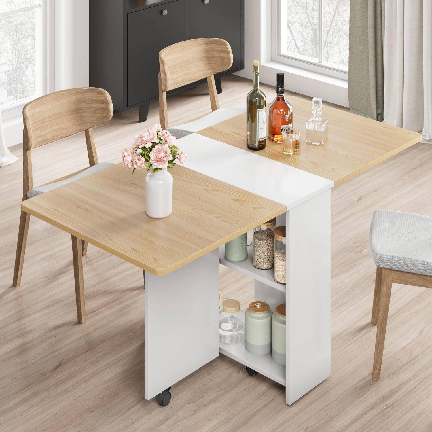 Moderner ausziehbarer Esstisch mit zwei Holzblättern, offenen Regalfächern, einer Vase mit Blumen und Flaschen oben drauf in einem hellen Raum mit Stühlen in der Nähe.