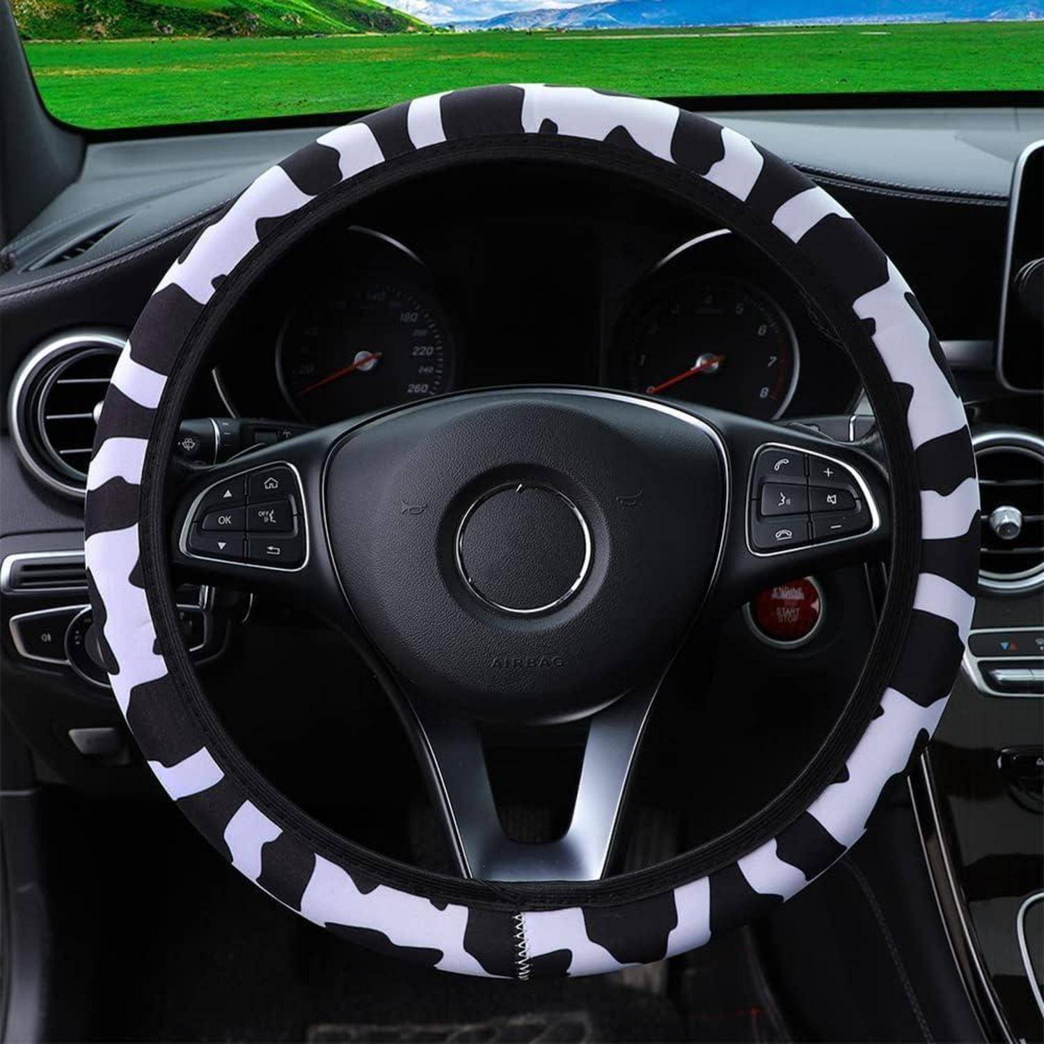 Autolenkrad mit schwarzweißem Zebrastreifenmuster-Bezug in einer Fahrzeugkabine.