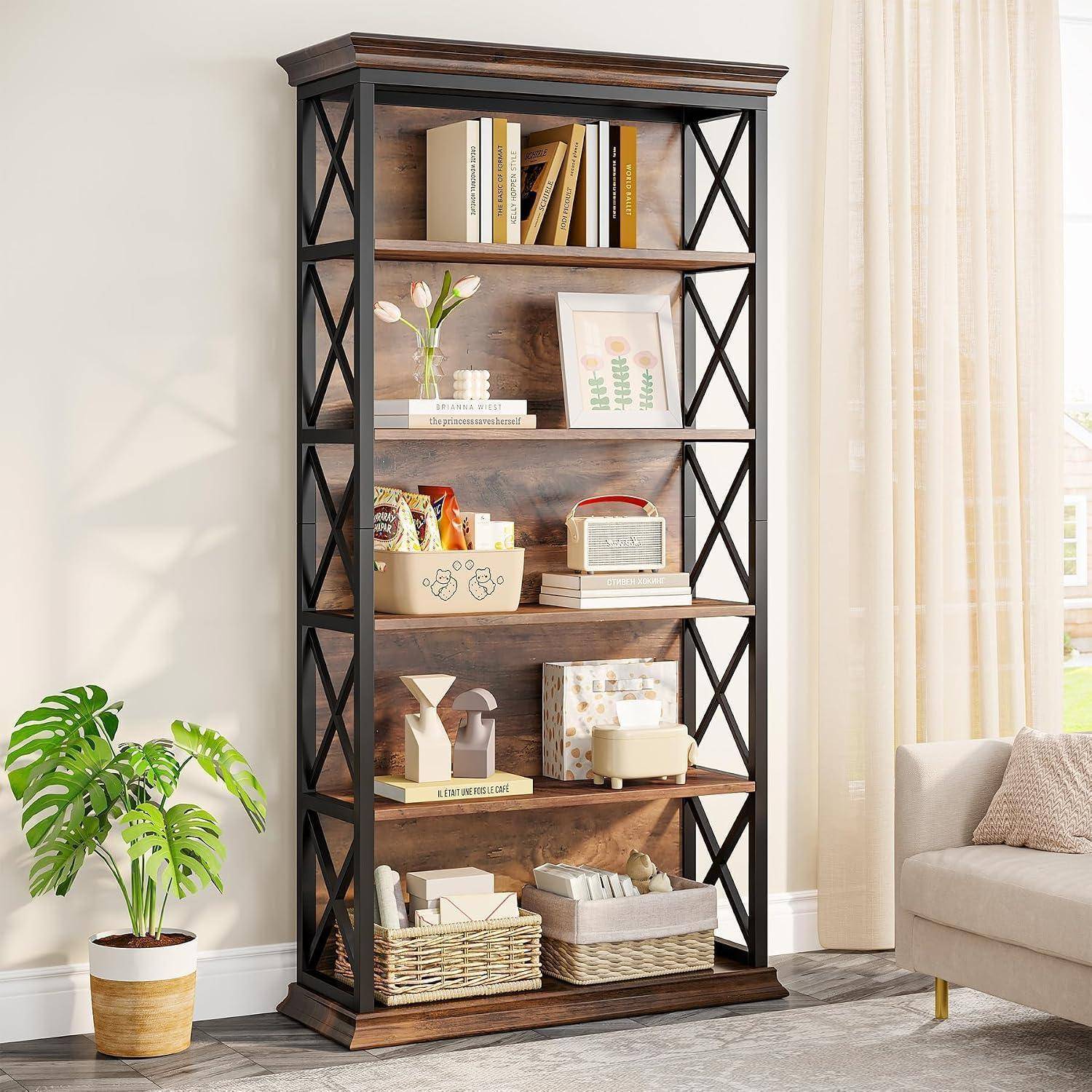 Ein hohes Bücherregal aus Holz mit schwarzen X-förmigen Seitenelementen zeigt Bücher, Dekoration, Körbe und ein kleines Radio in einem hellen Wohnzimmer.