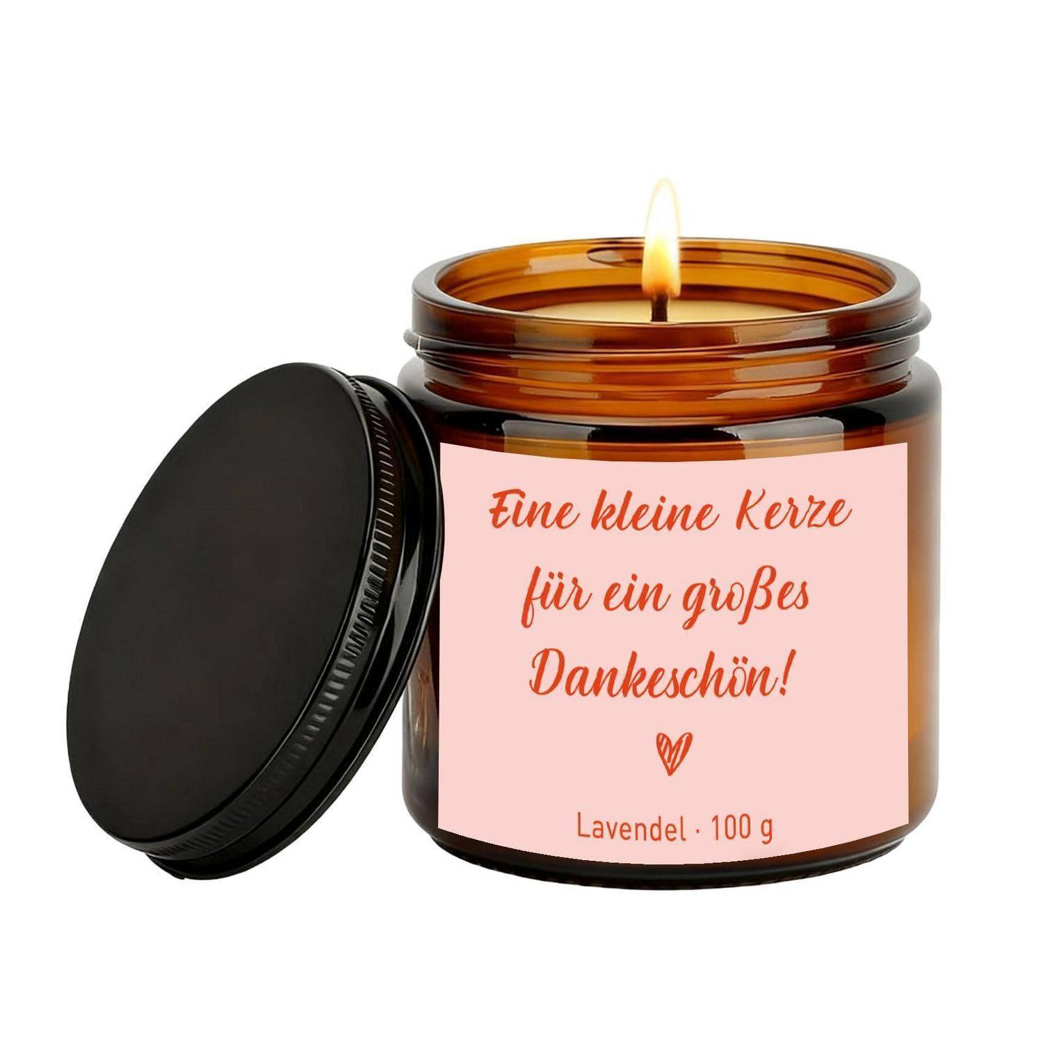 Bernsteinfarbenes Kerzenglas mit brennender Flamme und schwarzem Deckel daneben; das Etikett trägt die Aufschrift „Eine kleine Kerze für ein großes Dankeschön!