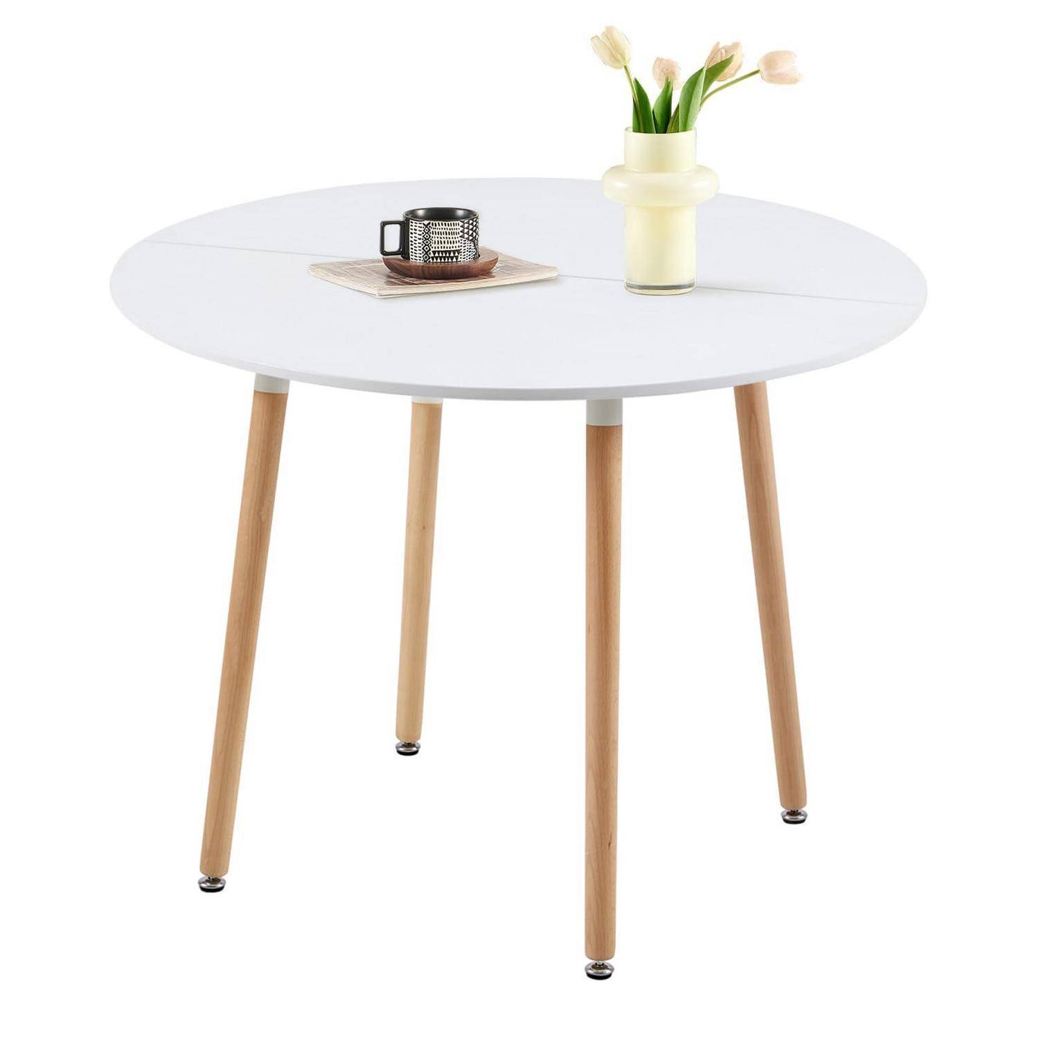 Runder weißer Tisch mit vier Holzbeinen, gestylt mit einer Tasse auf einem Untersetzer und einer Blumenvase oben drauf.