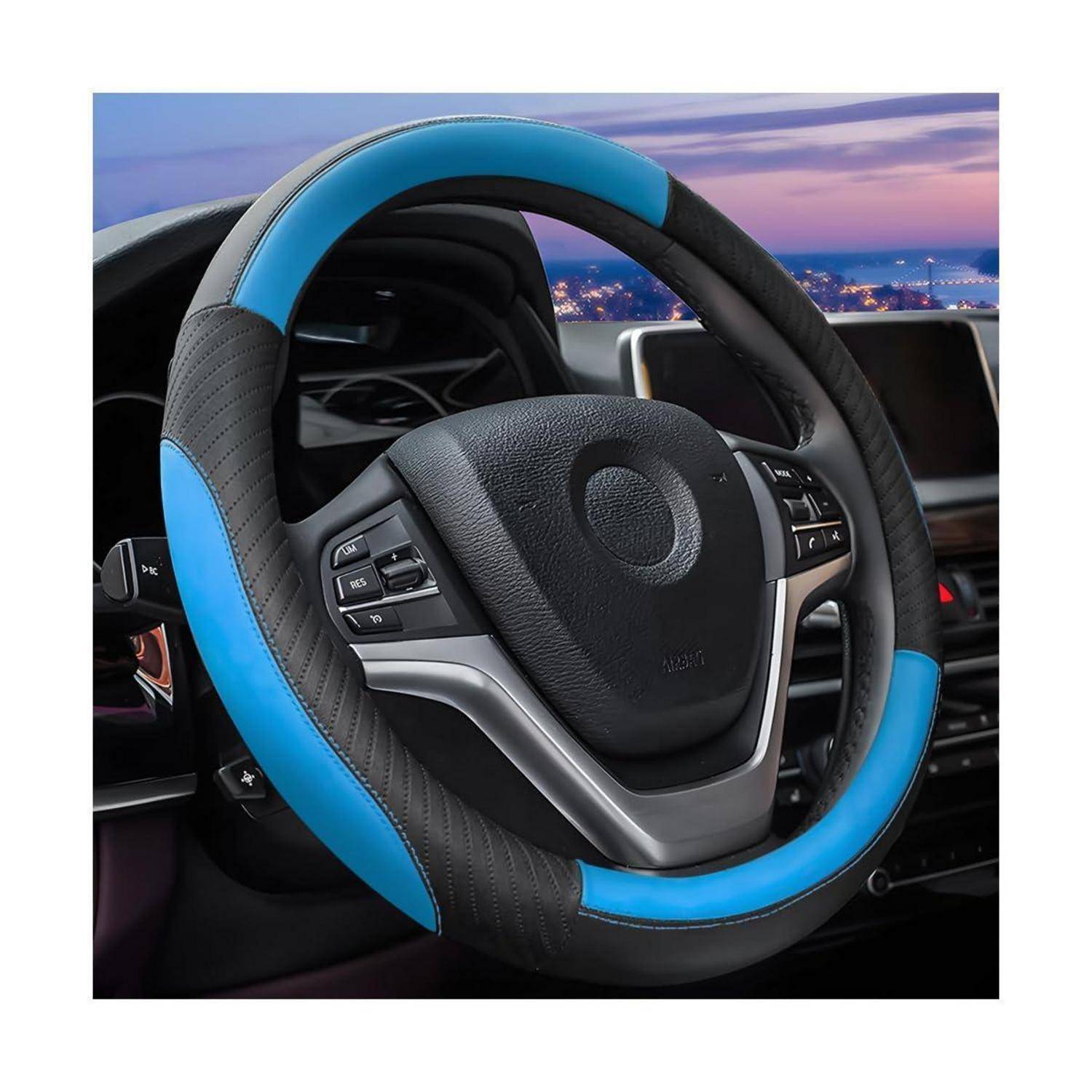 Blau-schwarze Lenkradbezug auf einem Autolenkrad, gezeigt im Inneren eines Fahrzeugs mit Armaturenbrett und Stadtlichtern im Hintergrund.