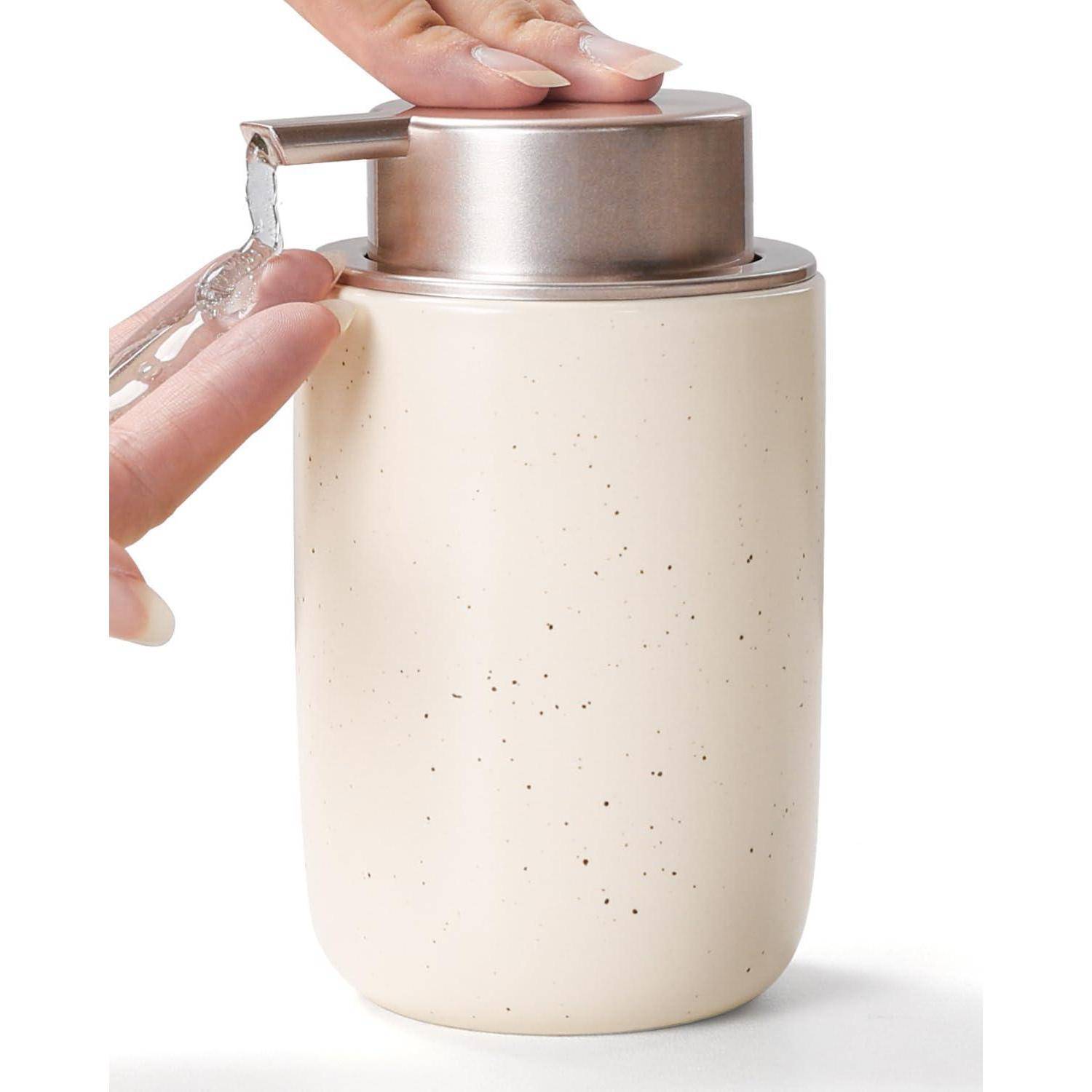 Hände drücken auf eine Pumpe an einer beigen isolierten Flasche und geben Wasser aus dem Auslauf in einen Becher ab.