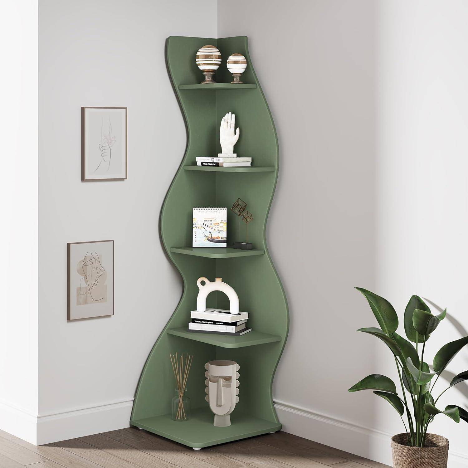 Grünes gewelltes Eckbücherregal mit dekorativen Objekten, Büchern, einer kleinen Vase und gerahmter Kunst neben einer Topfpflanze in einem hellen Raum.