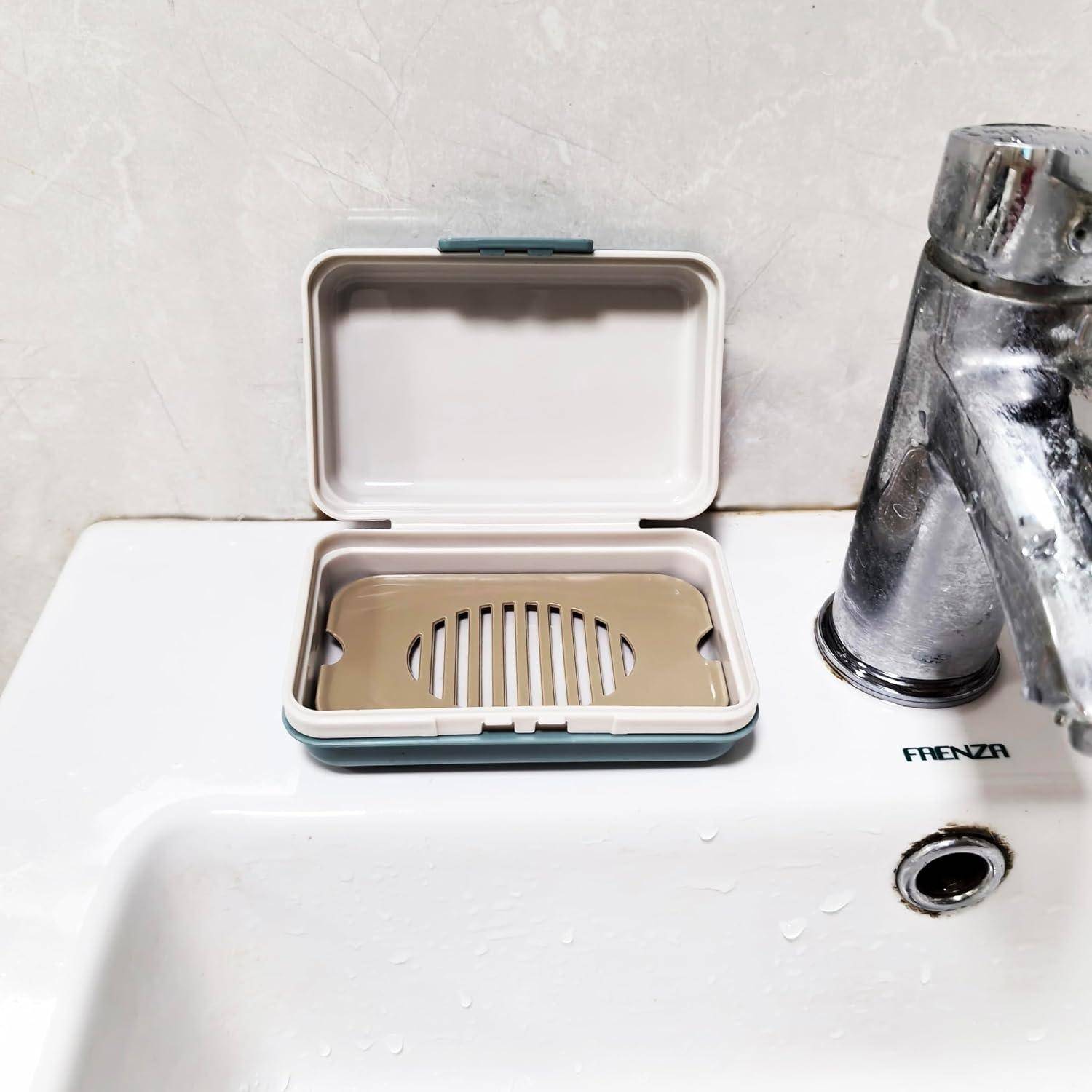 Eine offene, kompakte Seifenschale mit beigem Schlitzeinlage sitzt auf einem weißen Waschbecken neben einem verchromten Wasserhahn.