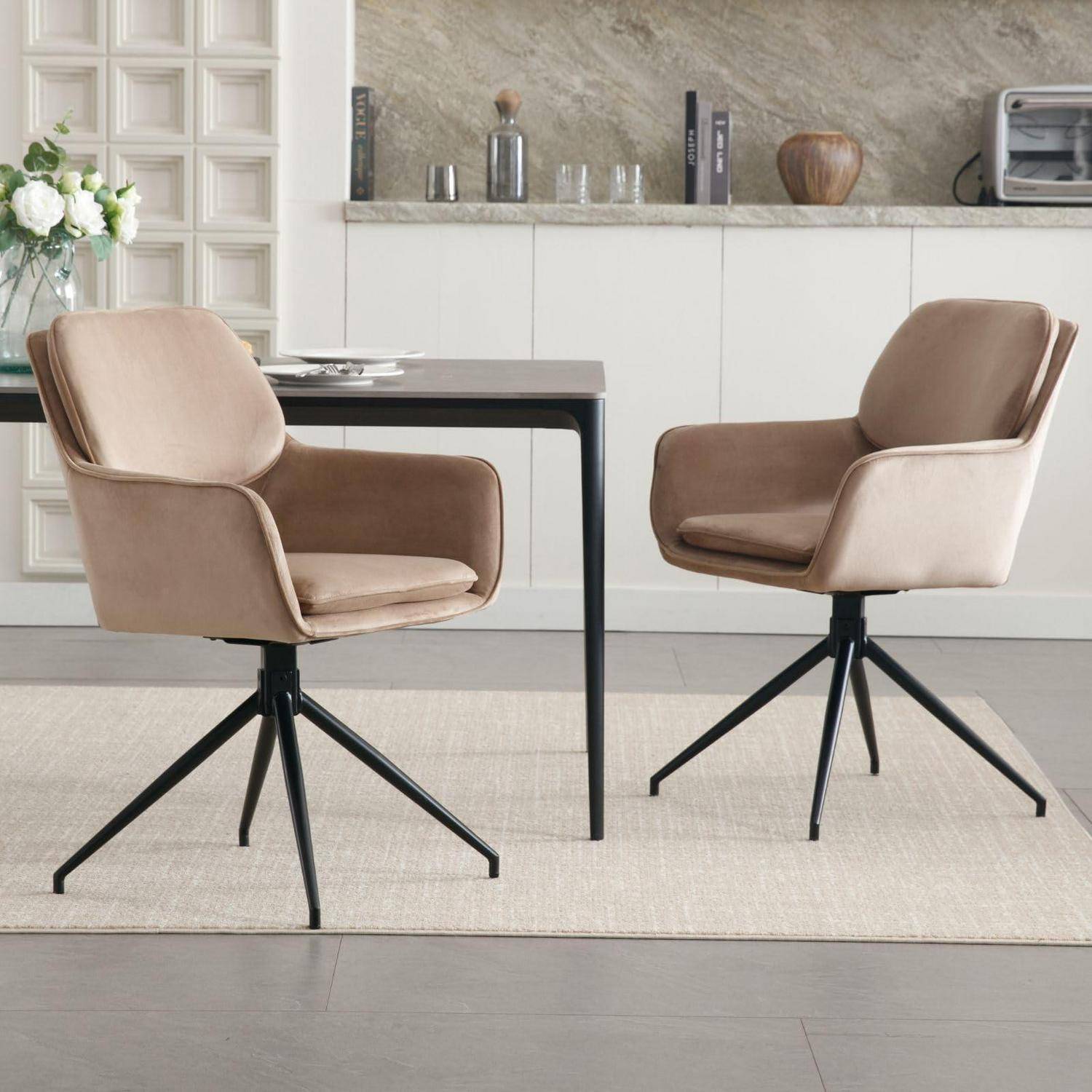 Zwei beige gepolsterte Drehstühle um einen kleinen dunklen Tisch in einem modernen Esszimmer mit hellem Teppich und neutraler Schrankwerk.