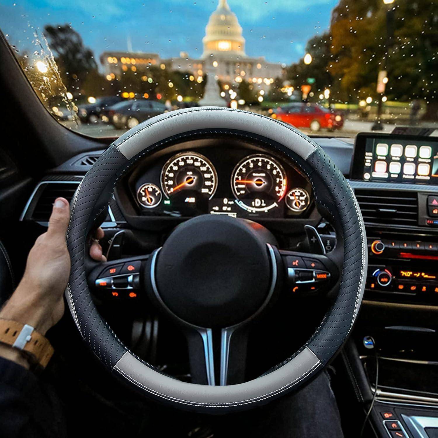 Fahrersicht aus dem Inneren eines Autos in der Dämmerung, mit Händen am Lenkrad, beleuchtete Armaturenbrettanzeigen und ein Stadtgebäude, das durch die Windschutzscheibe sichtbar ist.