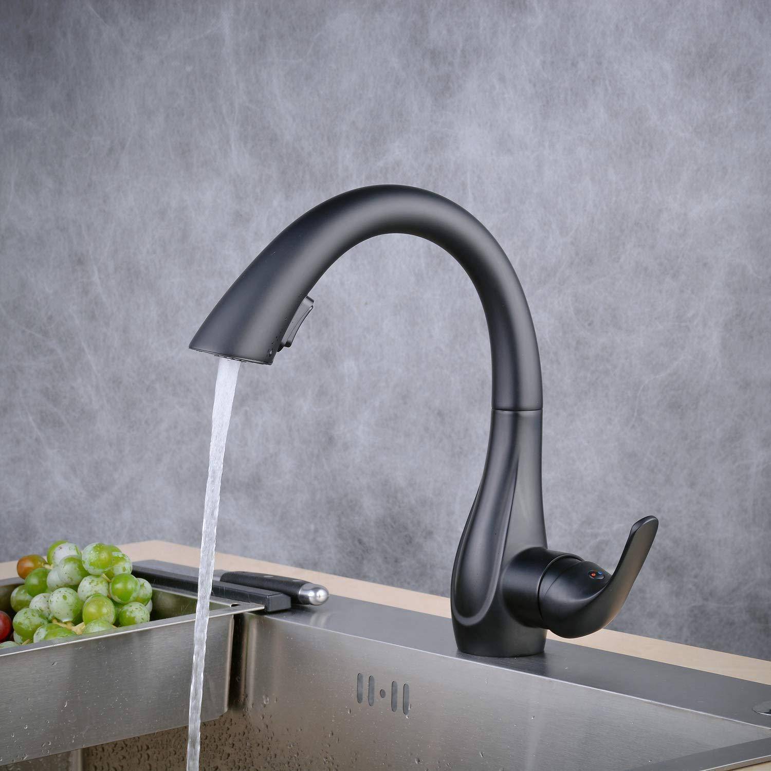 Schwarzer Küchenarmatur mit fließendem Wasser in ein Spülbecken neben einer Schüssel mit grünen Trauben.