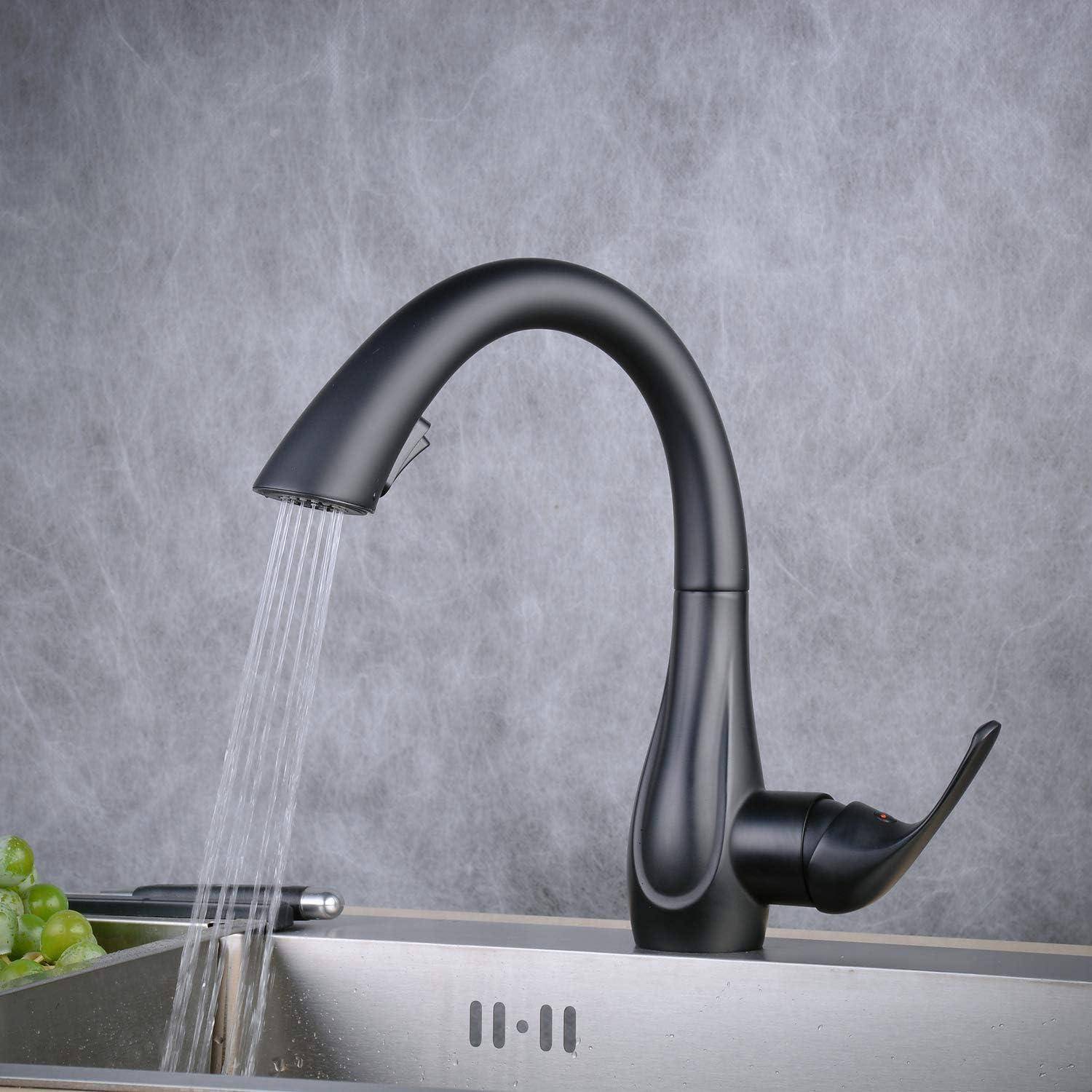 Schwarzer Wasserhahn mit gebogenem Auslauf in einer Edelstahlspüle, aus dem Wasser läuft; Trauben sitzen am linken Rand auf einer grauen Arbeitsplatte.