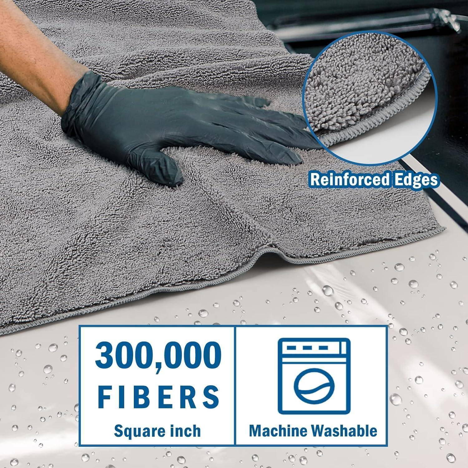 Graues Mikrofaser-Handtuch, das von einer behandschuhten Hand abgewischt wird, mit Callouts für „Verstärkte Kanten", „300.000 Fasern pro Quadratzoll"" und „Maschinenwaschbar"".