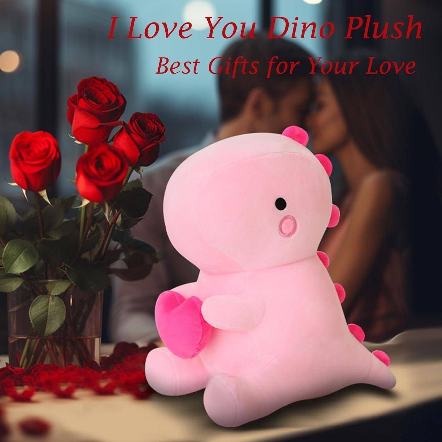 Rosa Dinosaurier-Plüsch, der ein Herz hält, neben roten Rosen, mit dem Text „Ich liebe dich Dino Plüsch" und „Die besten Geschenke für deine Liebe"".