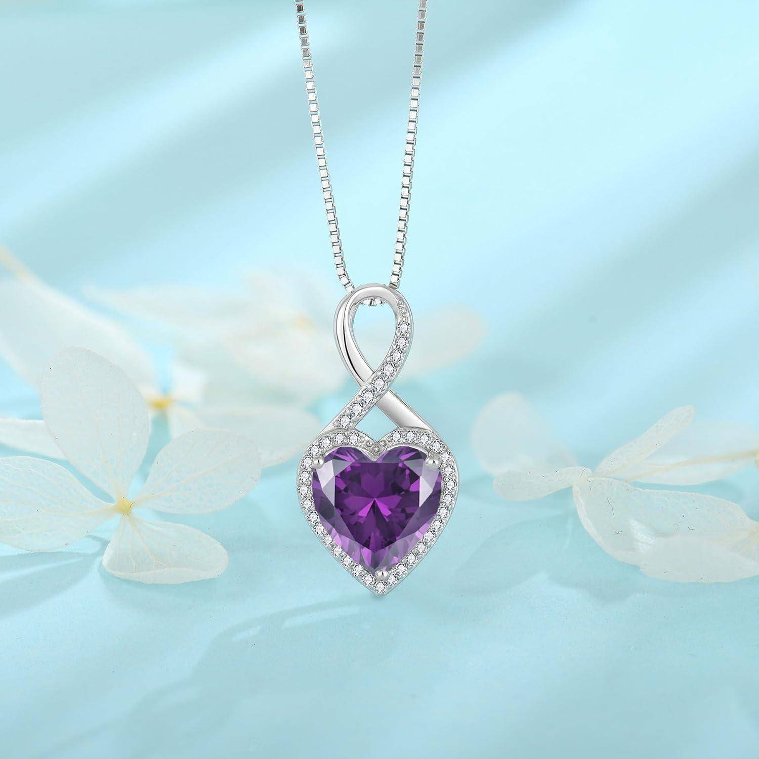 Silberner Herzanhänger-Halskette mit einem violetten Edelstein und diamantähnlichen Akzenten, gezeigt auf einem hellblauen blumigen Hintergrund.