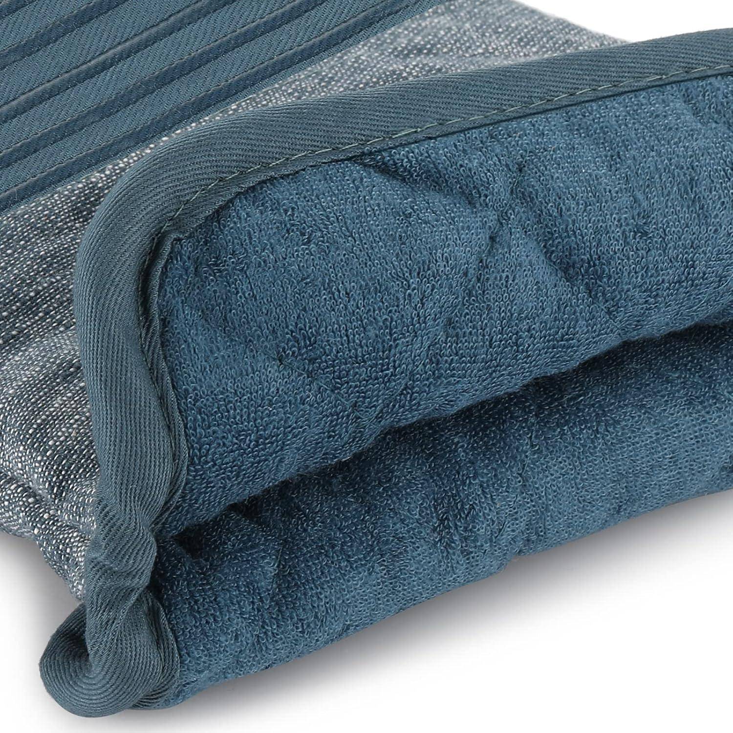 Nahaufnahme eines aufgerollten blauen strukturierten Handtuchs oder einer Decke mit gesticktem Saum und Schleifenkante auf weißem Hintergrund.