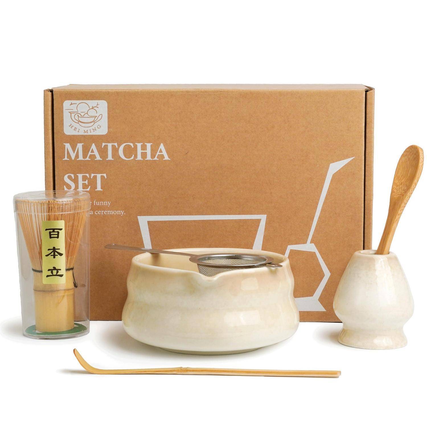 Matcha-Set mit verpackter Schachtel, keramischer Teeschale, Bambuslöffel und Schneebesen, Holzlöffel und einem Glaspokalbehältnis mit Matcha-Pulver.