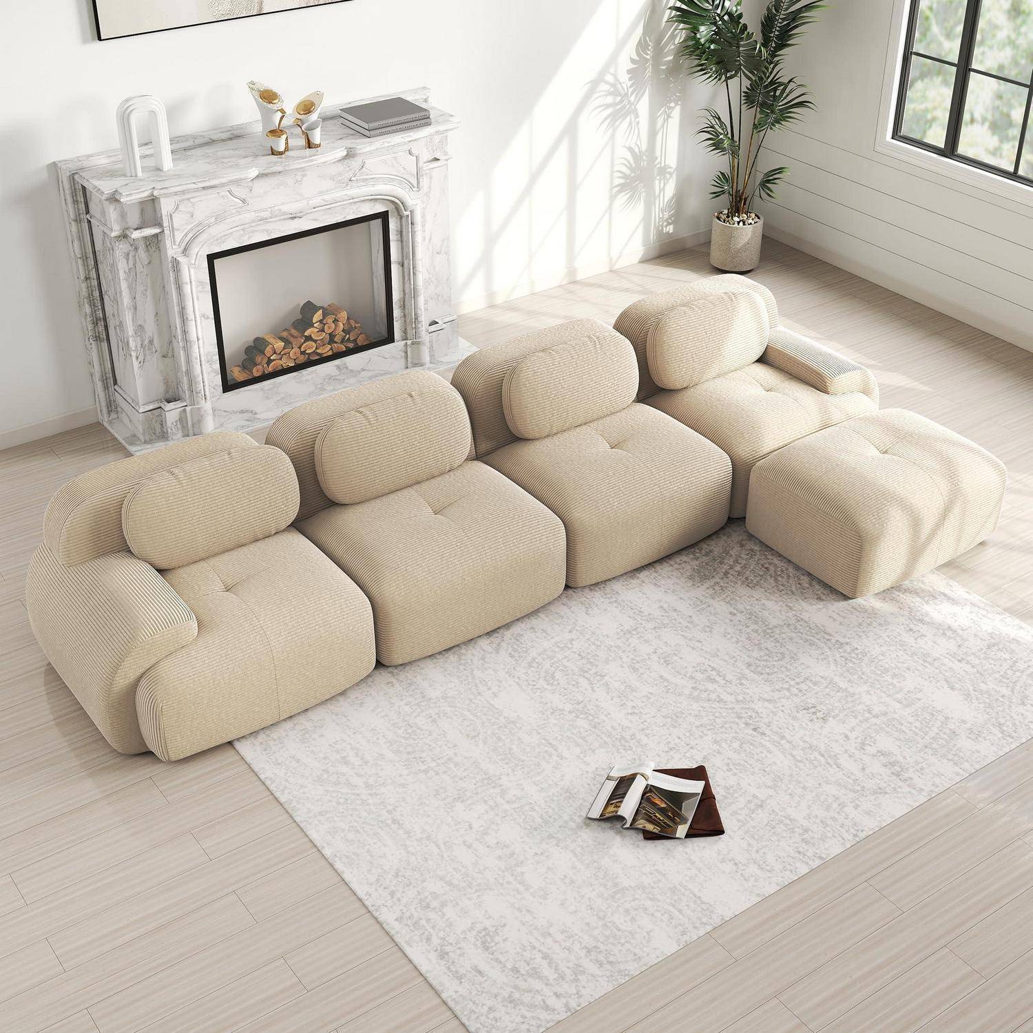 Beige modulares Ecksofa in einem hellen Wohnzimmer, angeordnet um einen Kamin auf einem hellen Teppich mit einer Pflanze und einem Fenster in der Nähe.