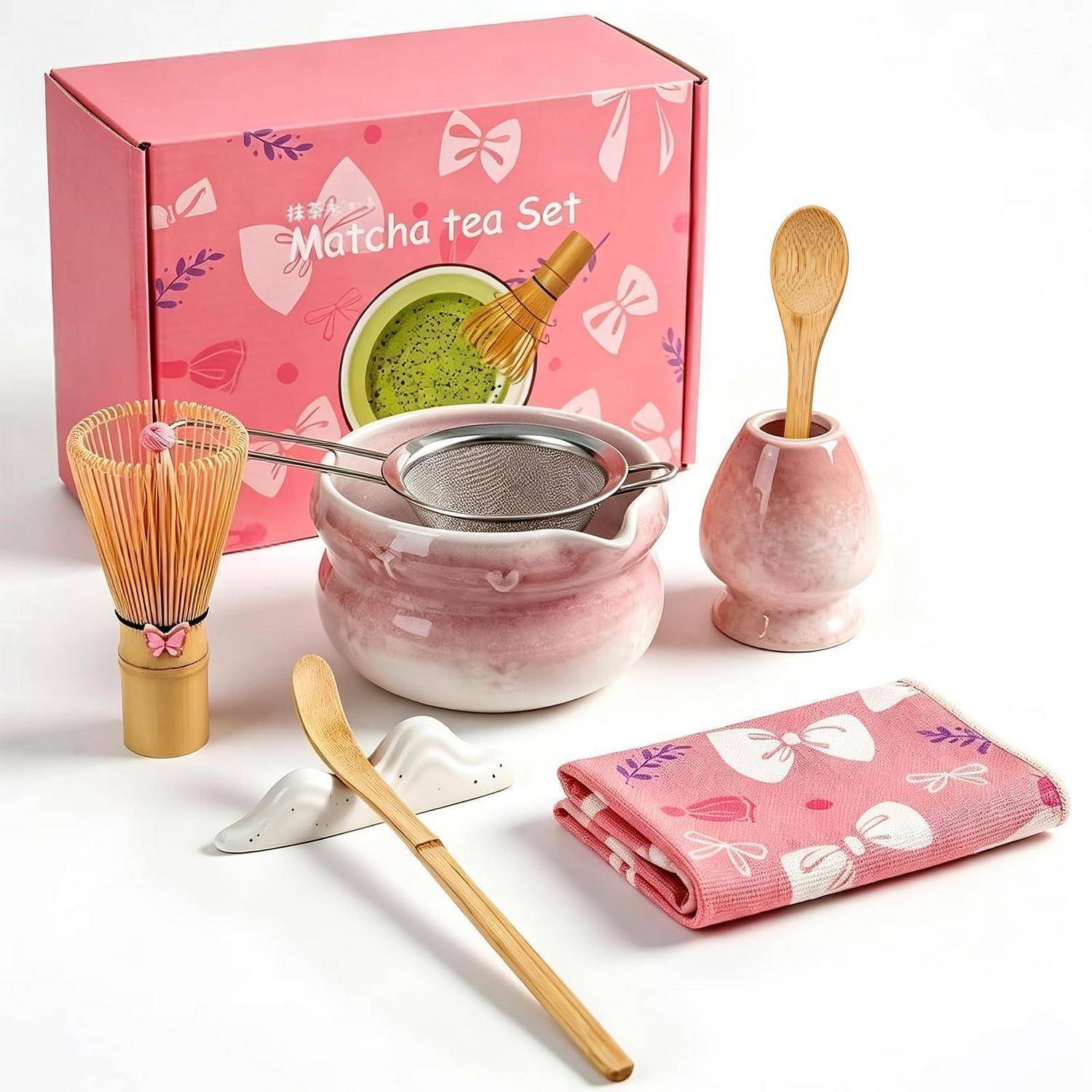 Rosa Matcha-Tee-Set mit Schale, Besen, Sieb, Löffel, Besenständer, Teelöffel und Tuch, dargestellt mit dekorativem Aufbewahrungskarton.