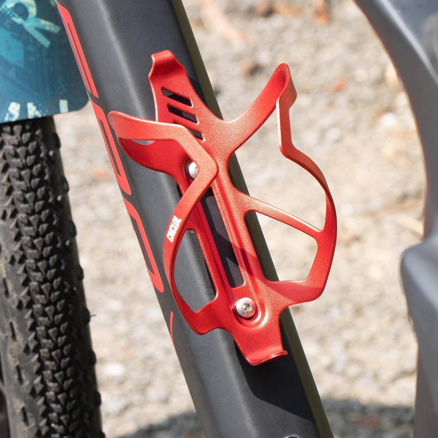 Nahaufnahme eines roten Fahrrad-Flaschenhalters, der an einem mattschwarzem Fahrradrahmen montiert ist.
