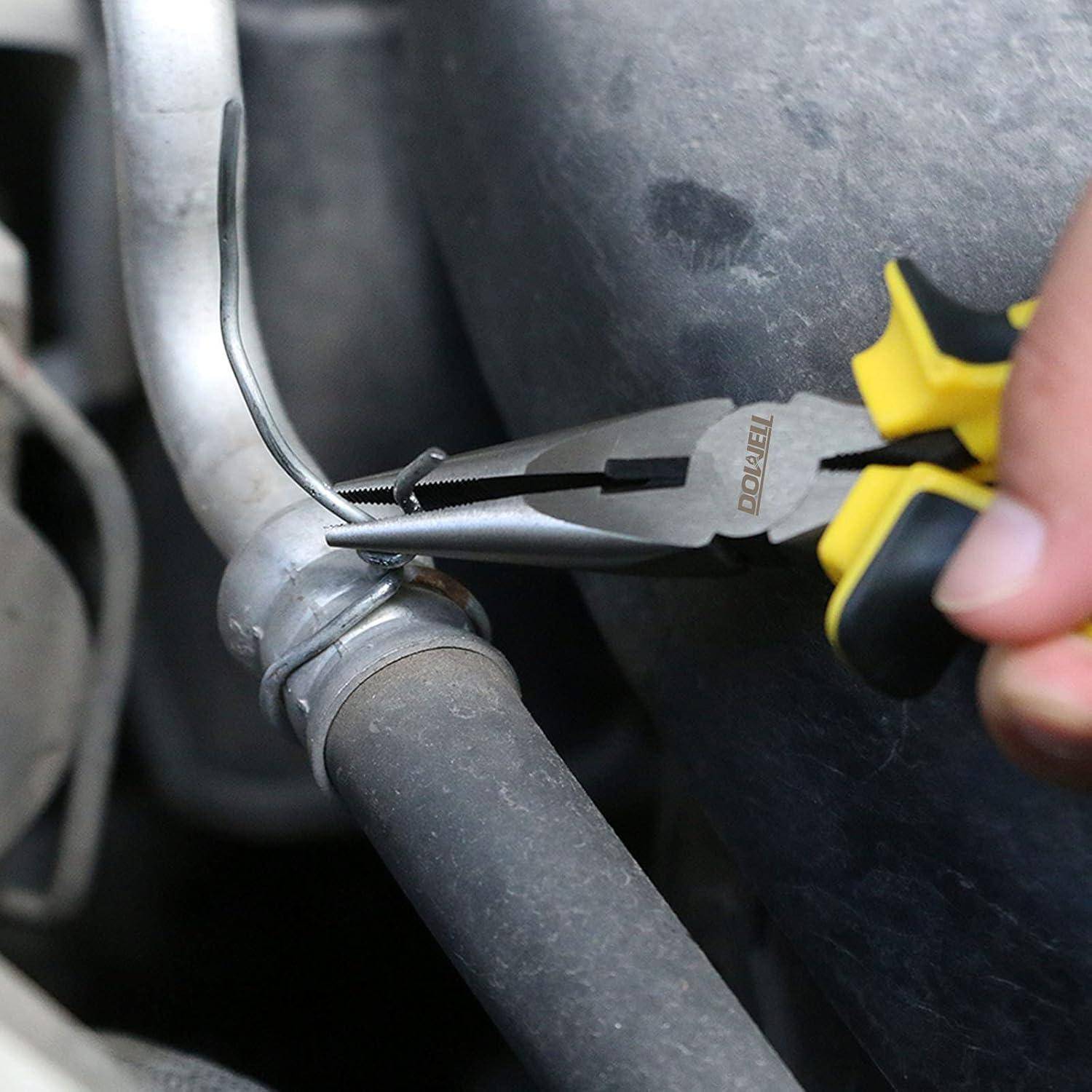 Nahaufnahme einer Zange, die eine kleine Metallschelle an einem Schlauch oder Kabel im Motorraum festzieht.