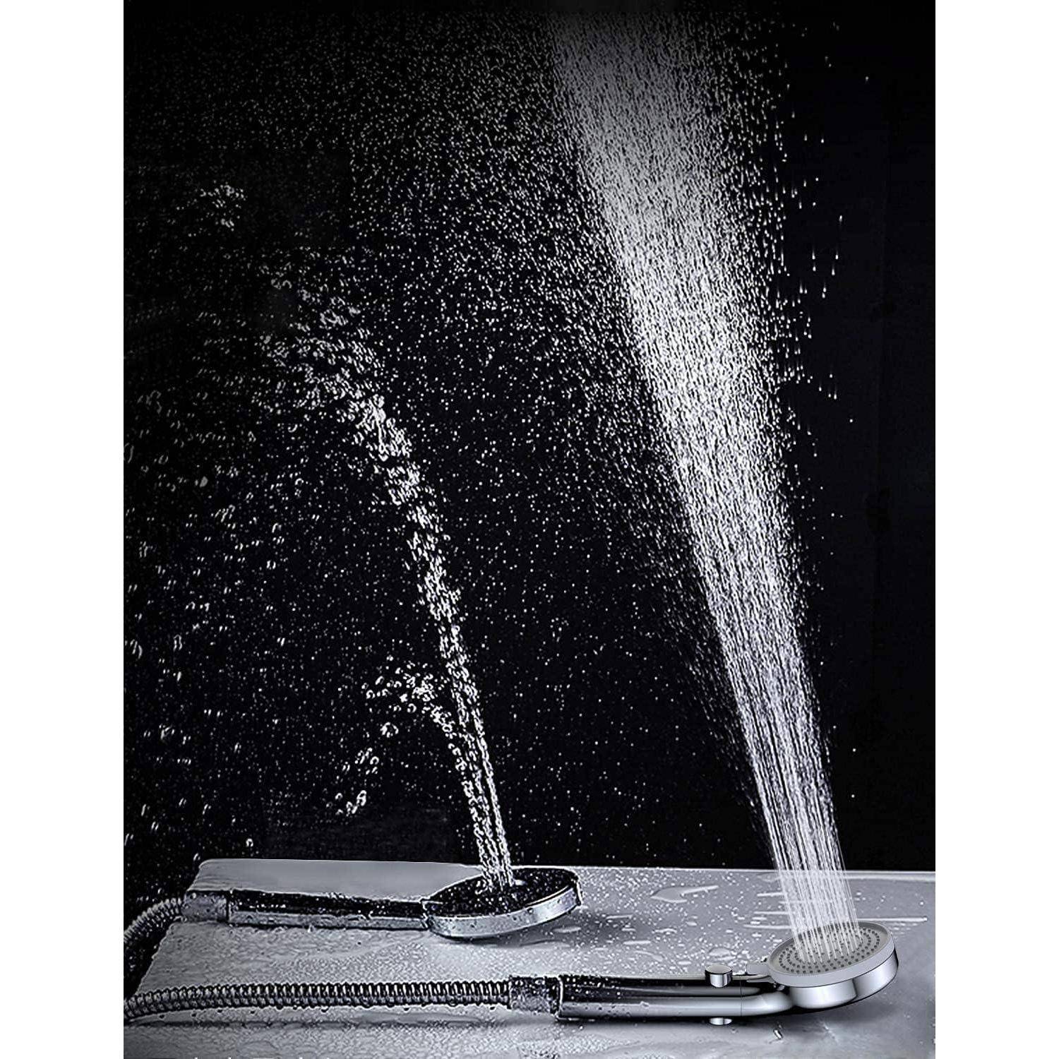 Zwei tragbare Duschköpfe, die starke Wasserstrahlen gegen einen schwarzen Hintergrund sprühen, auf einer Arbeitsplatte mit angebrachten Schläuchen dargestellt.