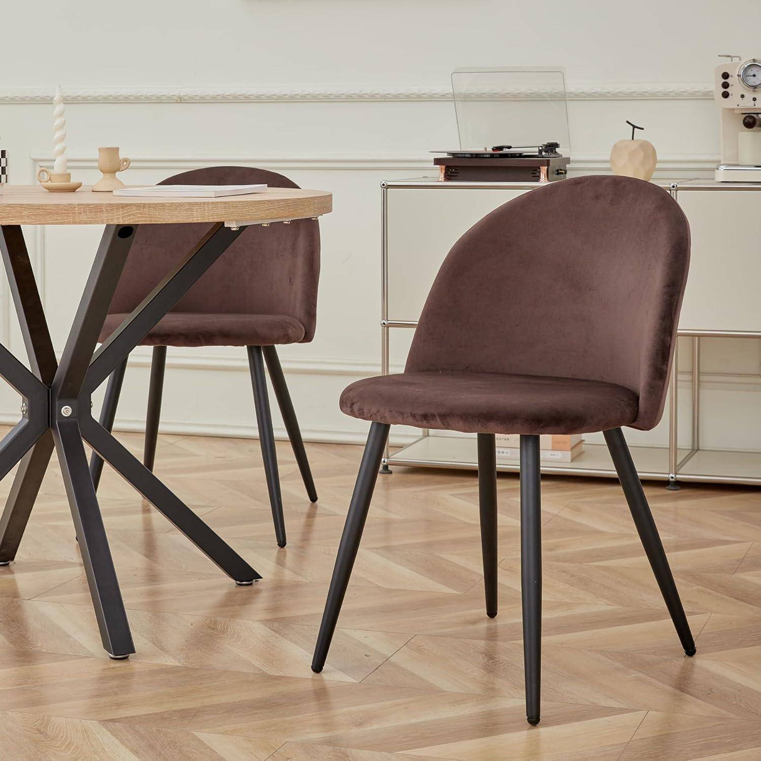 Brauner gepolsterter Esszimmerstuhl mit schwarzen Beinen neben einem Tisch aus hellem Holz in einem modernen Esszimmer.