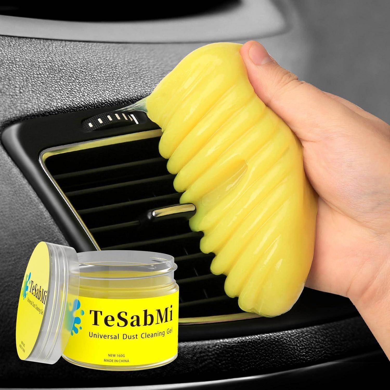 Handliches Reinigen einer Autolüftung mit gelbem Gel-Staubreiniger; Produktglas mit der Bezeichnung „TeSabMi