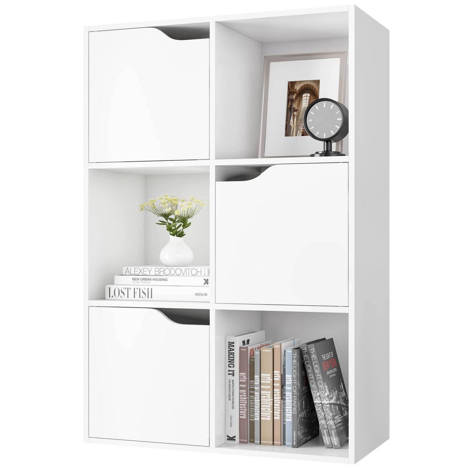 Weißer Würfelregalorganizer mit sechs Fächern, von denen einige durch weiße Türen verschlossen sind; ausgestellte Gegenstände umfassen Bücher, eine Blumenvase, ein gerahmtes Foto und eine kleine Uhr.