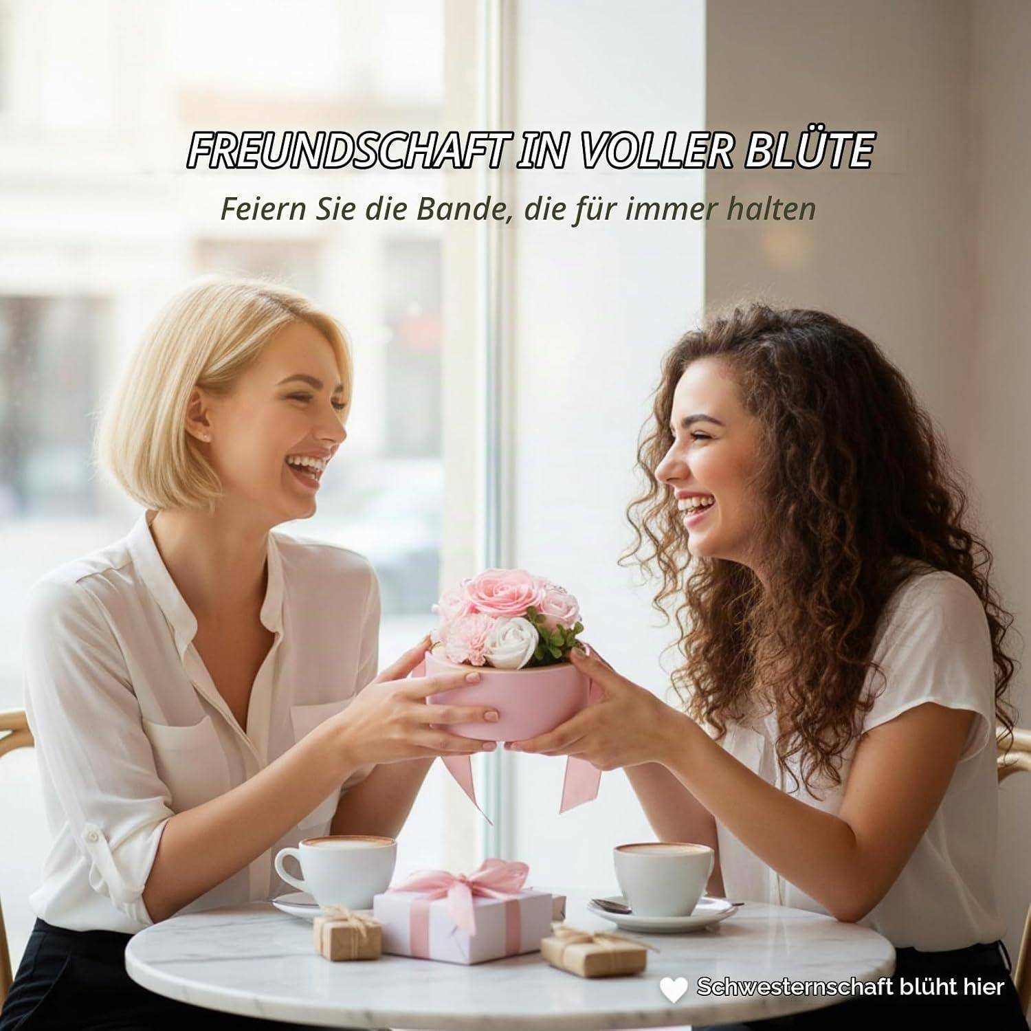 # Zwei lächelnde Frauen in einem Café tauschen ein rosa Blumengeschenk aus und teilen sich Tee, mit deutschem Text über aufblühende Freundschaft und Schwesterlichkeit.