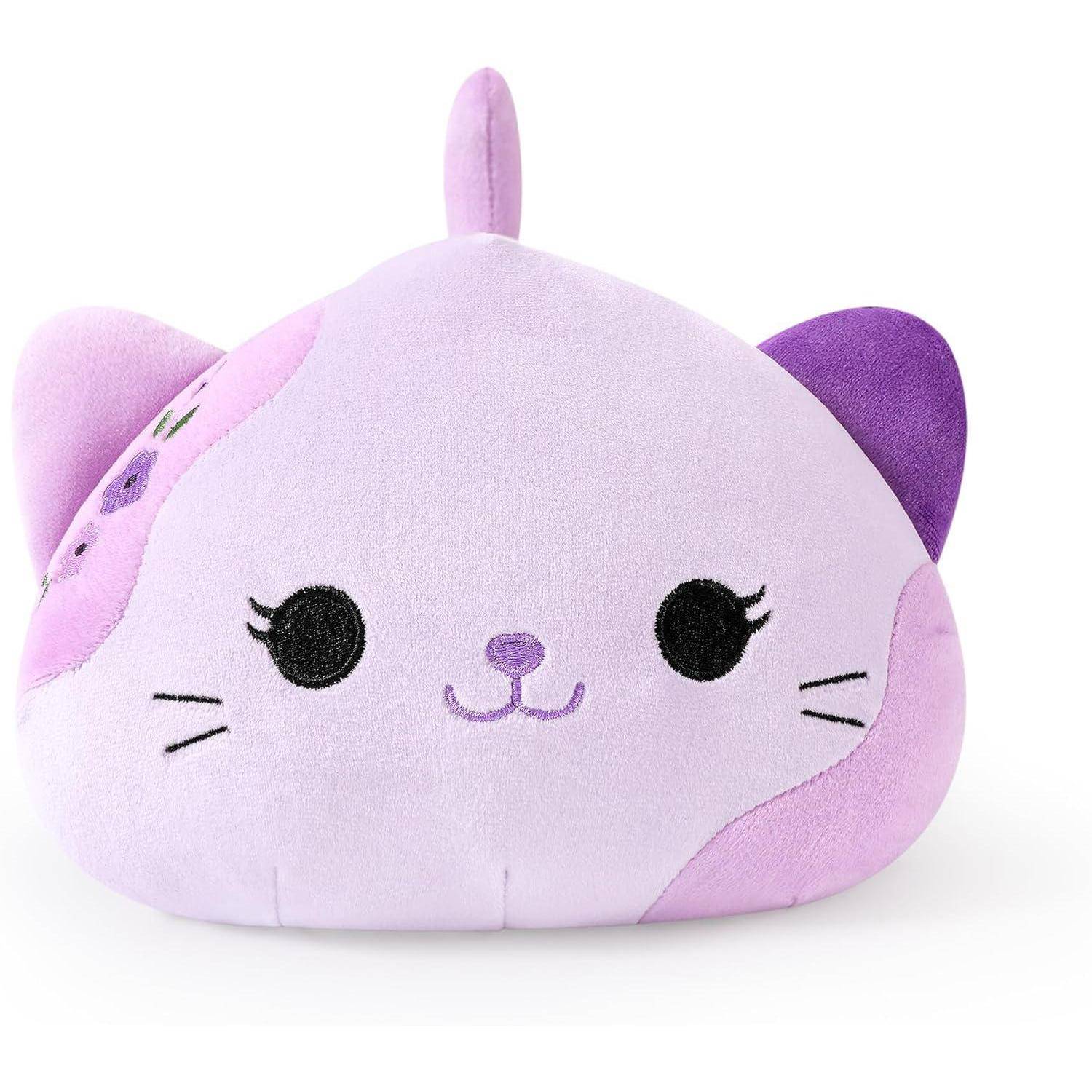 Ein violettes, katzenförmiges Plüschtier mit einem lächelnden Gesicht und kleinen Ohren, gezeigt vor einem weißen Hintergrund.
