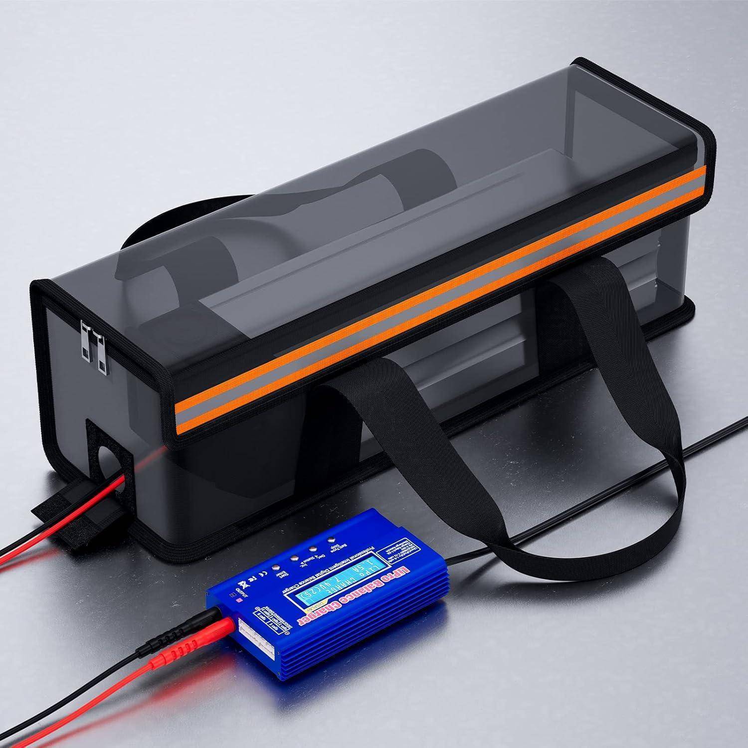 Ein tragbarer schwarzer Aufbewahrungskoffer mit transparentem Deckel und orangem Streifen, verbunden durch Kabel mit einem blauen elektronischen Gerät und Trageband.