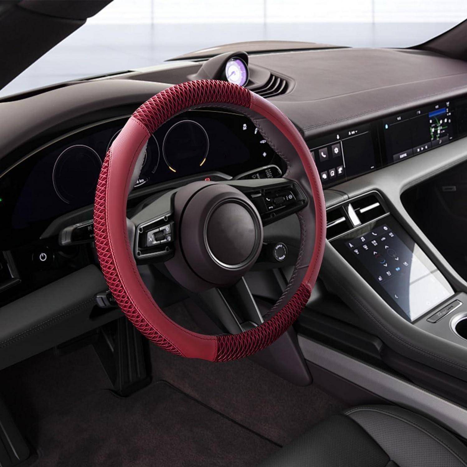 Autoinnenraum mit rotem Lenkradüberzug, digitalem Armaturenbrett, zentralem Touchscreen und einem kleinen Messgerät, das oben auf dem Armaturenbrett montiert ist.