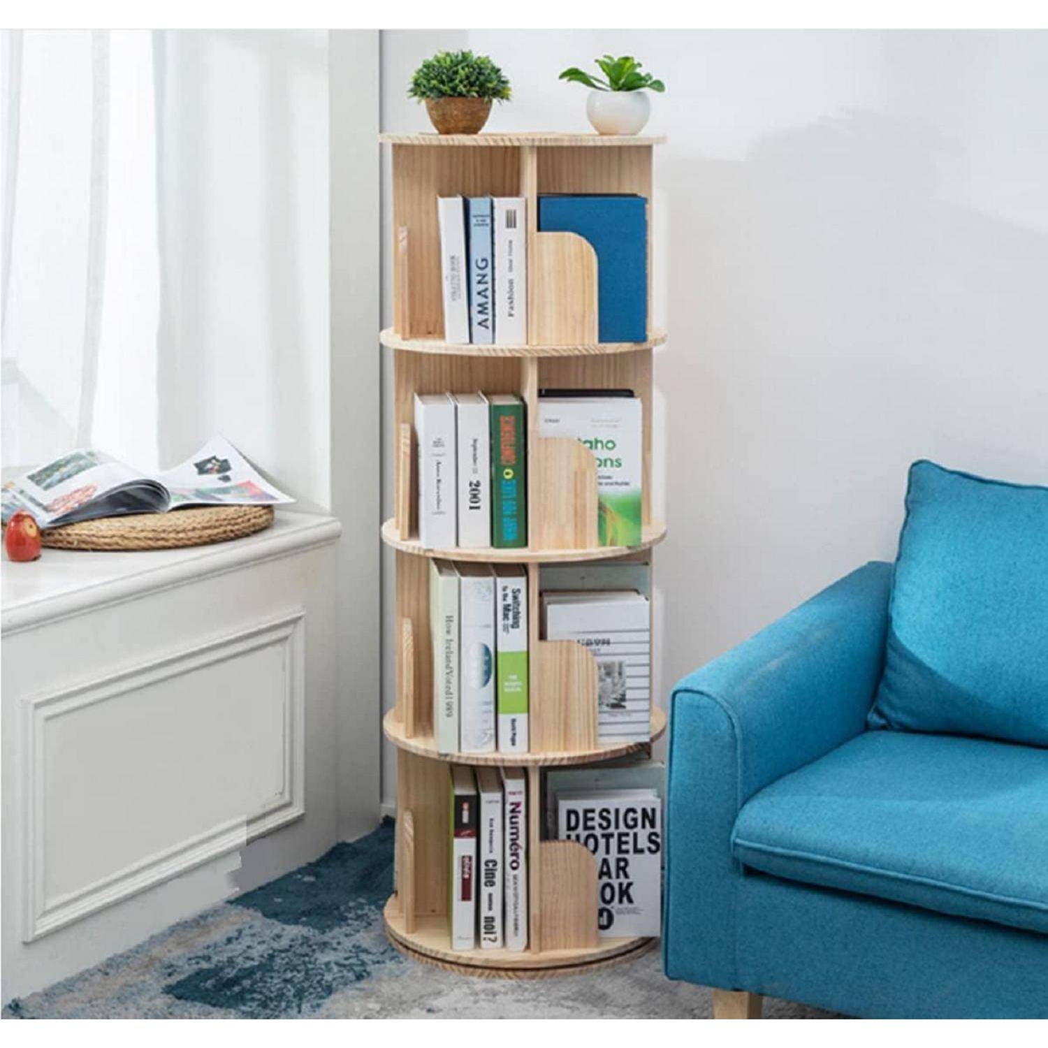 Hohes rundes Holzregal mit Büchern und kleinen Topfpflanzen neben einem blauen Sofa in einem hellen Wohnzimmer.