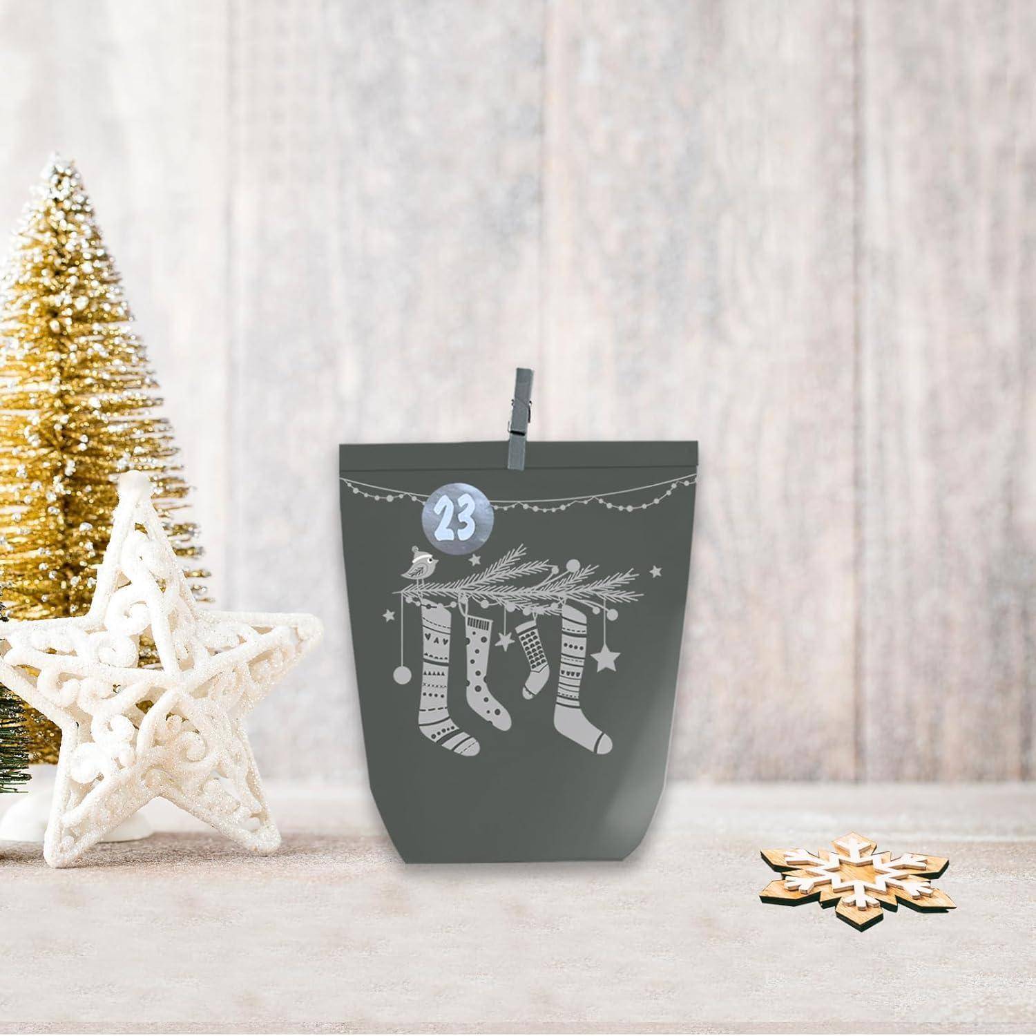 Festliche grau-weiße Weihnachtsgeschenktüte mit einer Wäscheleine-Klammer mit der Aufschrift 