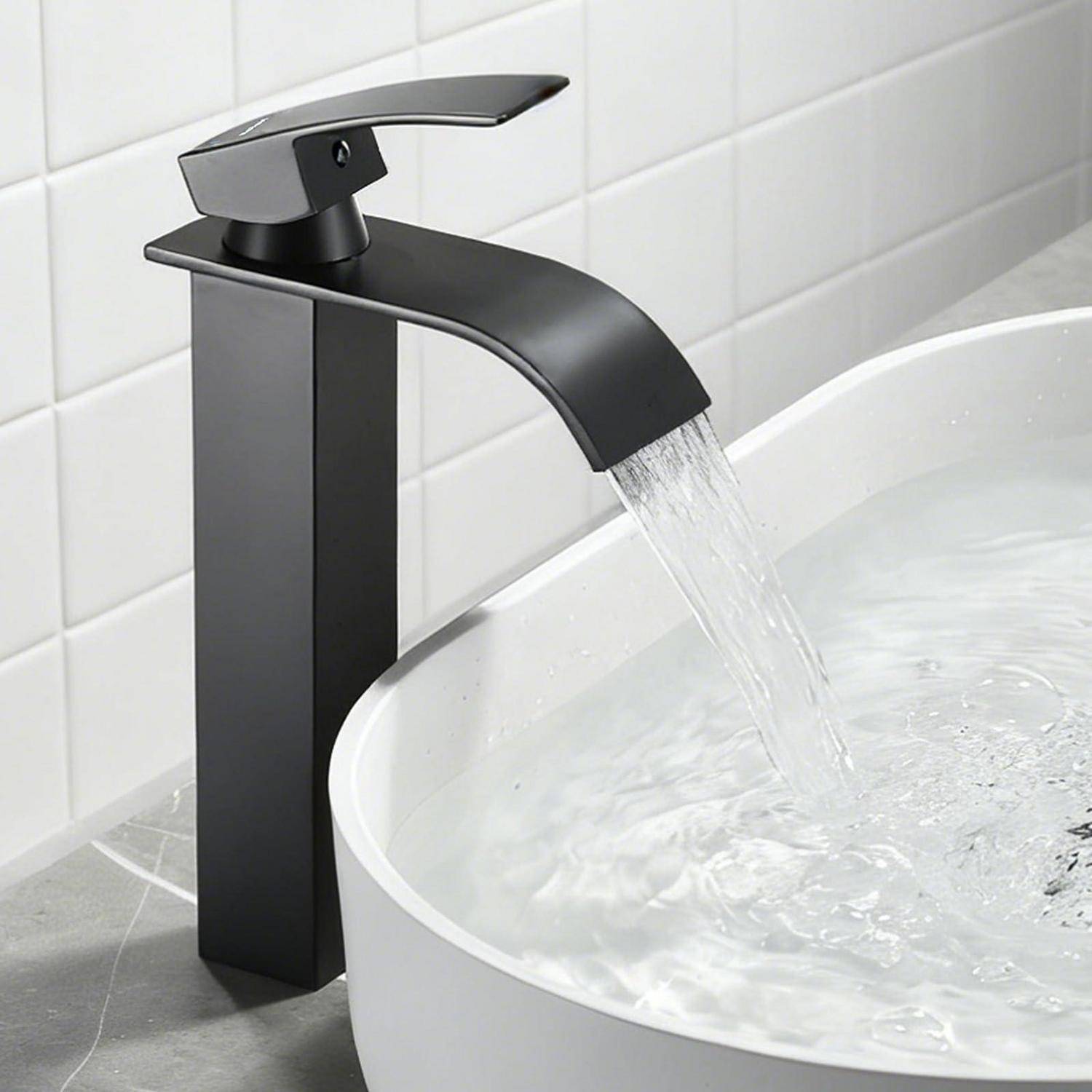 Moderner schwarzer Wasserhahn im Badezimmer, der Wasser in ein weißes Aufsatzwaschbecken gegen weiße geflieste Wände gießt.