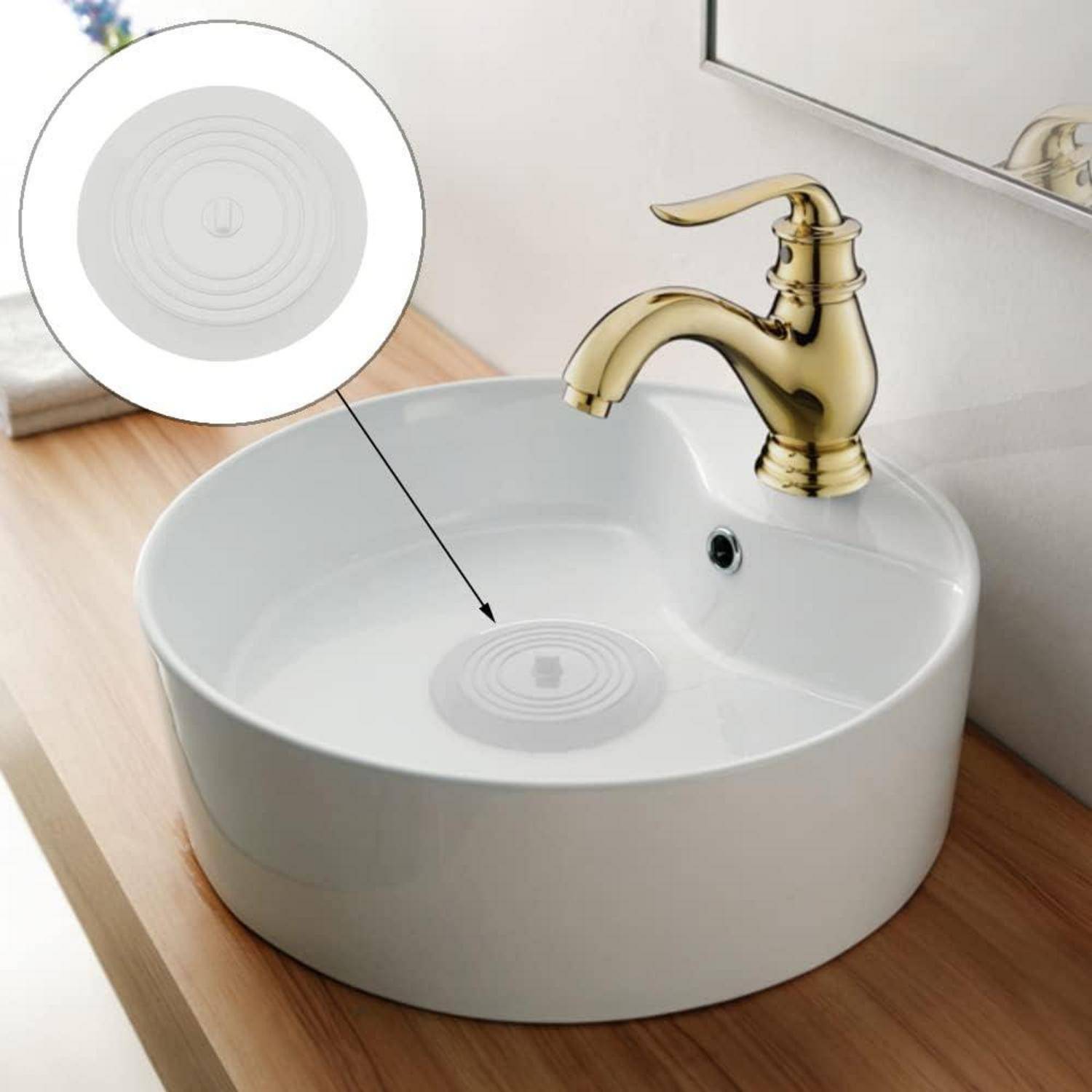 Rundes weißes Waschtisch-Waschbecken mit goldenem Wasserhahn; die Vergrößerung zeigt eine Nahaufnahme des im Becken zentrierten Abflussgitters des Waschbeckens.