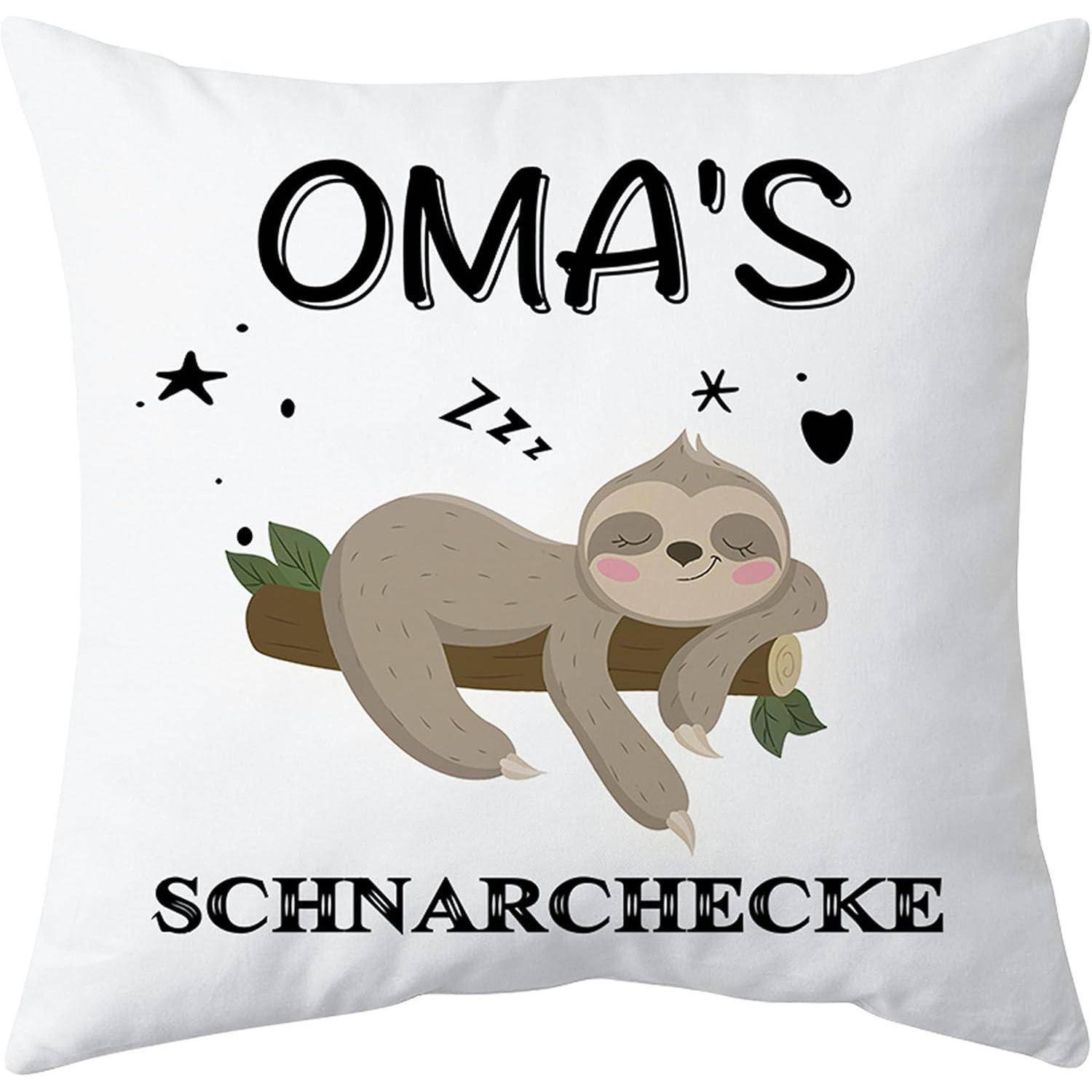 Weißes Kissen mit einem schlafenden Cartoon-Faultier auf einem Ast und dem Text „OMA'S SCHNARCHECKE