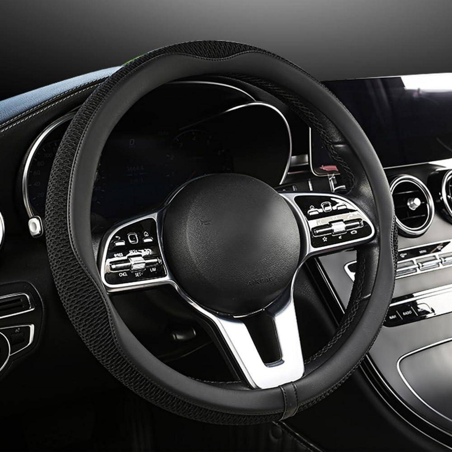 Nahaufnahme eines Luxusauto-Lenkrads und eines Armaturenbretts mit digitalen Bedienelementen und runden Lüftungsdüsen.