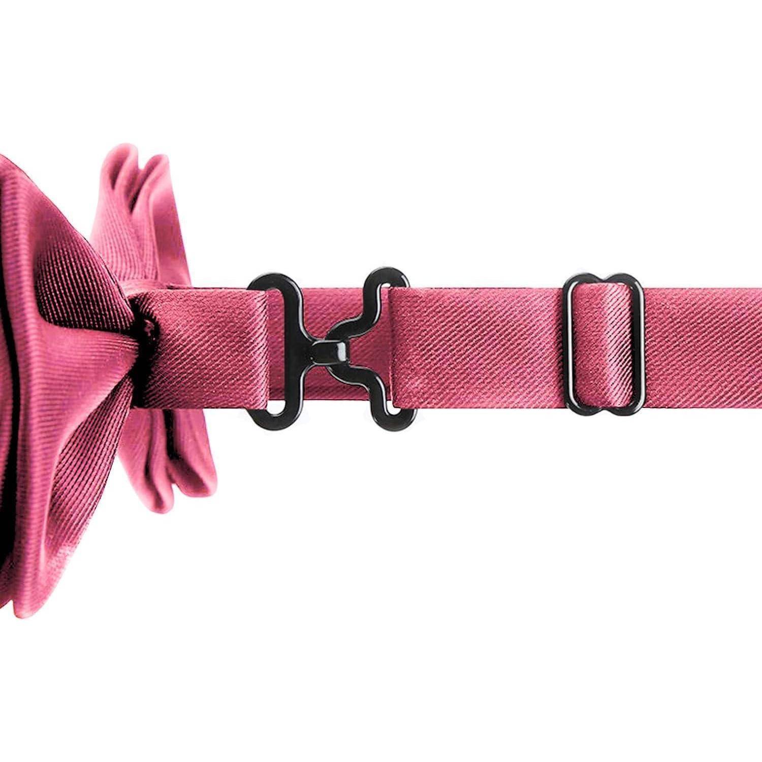 Nahaufnahme eines rosa Riemens, der durch schwarze Kunststoffschnallen verbunden ist und einen verstellbaren Schieber auf weißem Hintergrund aufweist.