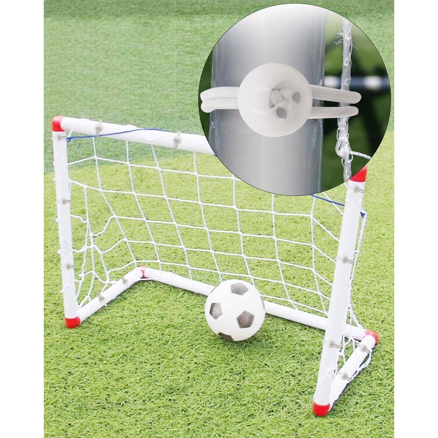 Mini-Fußballtor mit Ball im Inneren auf künstlichem Rasen, mit einer Nahaufnahme im Einsatz, die eine Kunststoffklemme oder einen Befestigungsklemmen zeigt, die am Netz befestigt ist.
