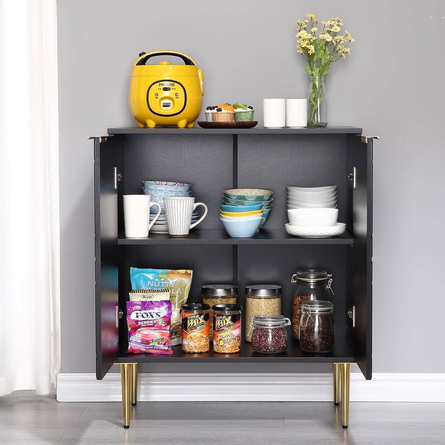 Offener schwarzer Schrank, der als Küchenregal verwendet wird und ein gelbes Gerät, Tassen, Schüsseln, Gläser, Snacks und eine Blumenvase enthält.