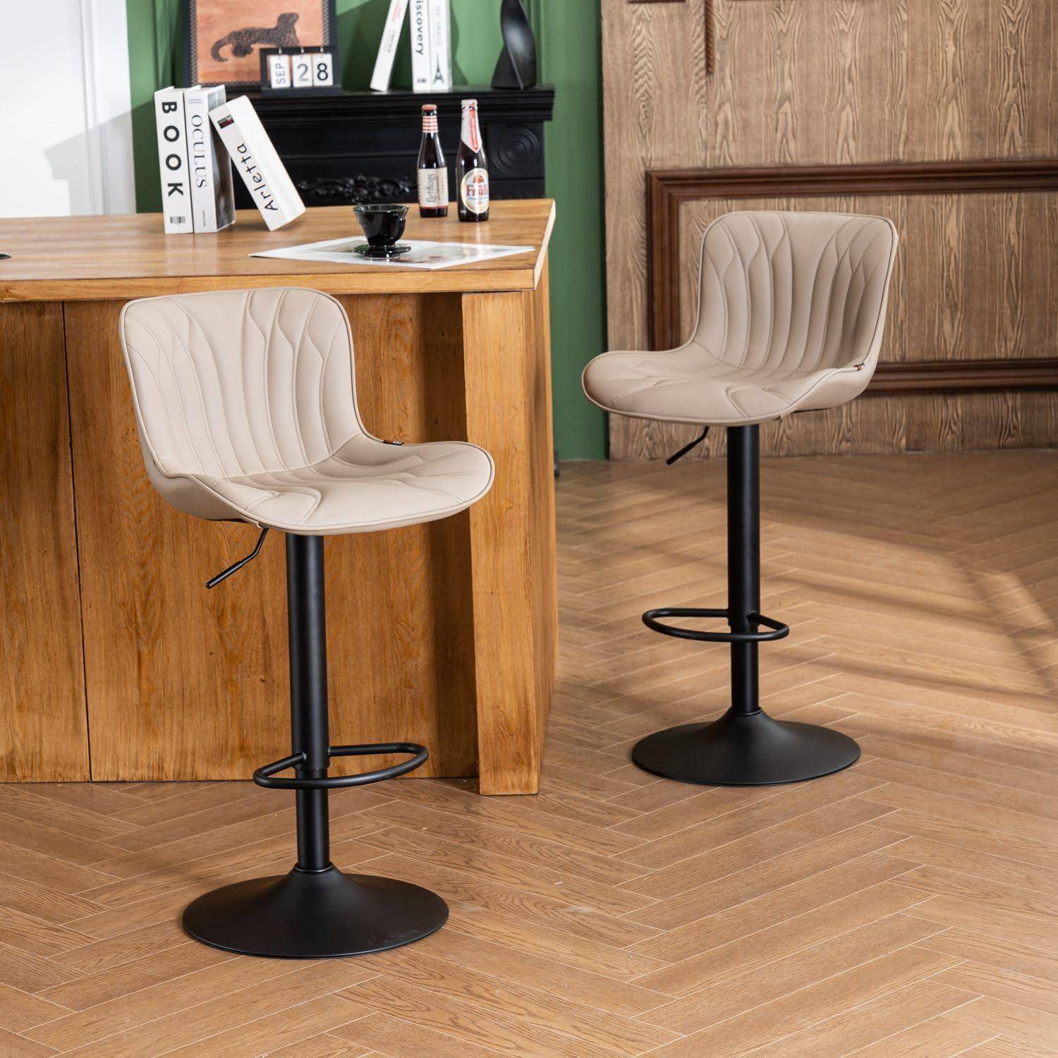 Zwei beige drehbare Barhocker mit schwarzen Basen in einem Raum mit Holzboden neben einer Holztheke.