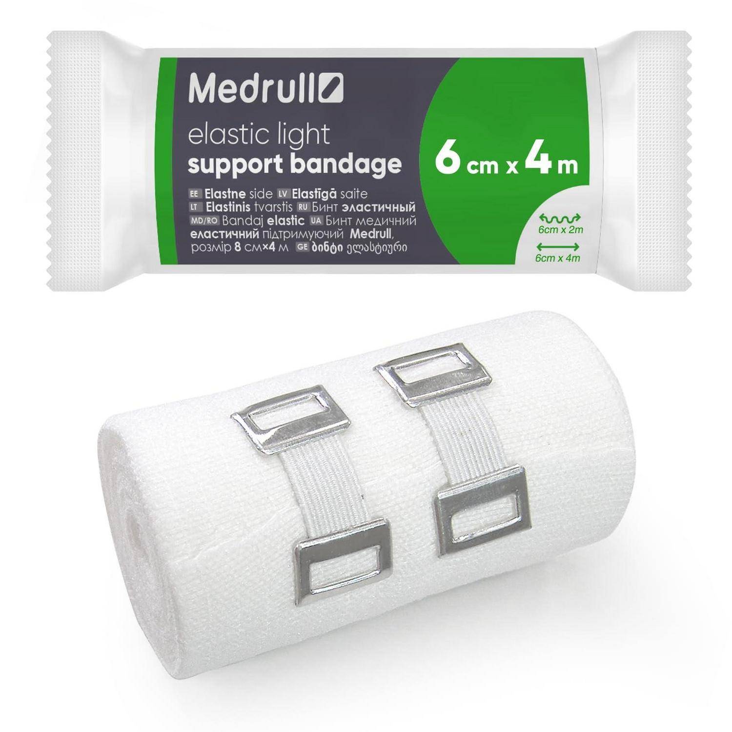 Medrull elastische leichte Stützbandage, 6 cm x 4 m, gezeigt gewickelt und aufgerollt mit zwei Metallclips.