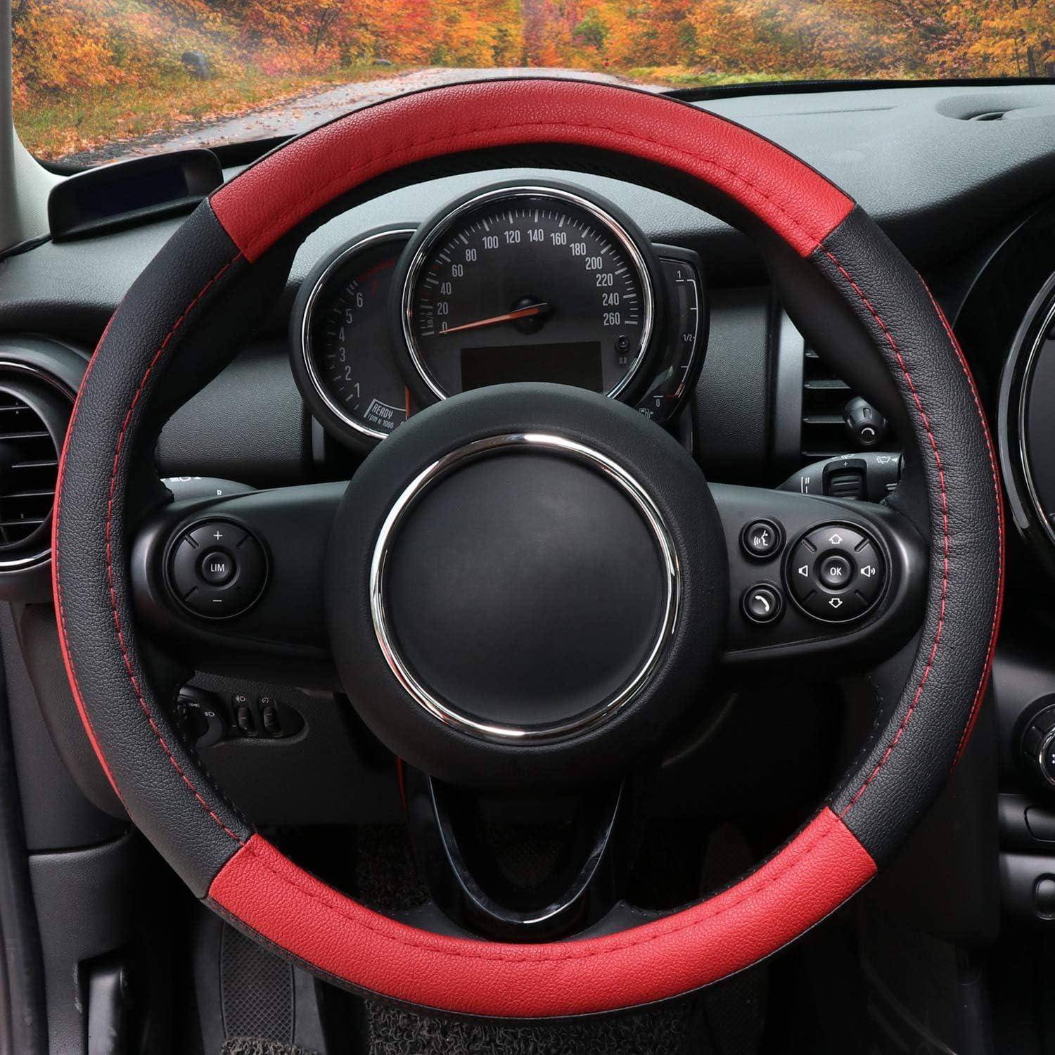 Nahaufnahme eines Autolenkrads mit rot-schwarzem Bezug, Armaturenbrettinstrumente sind dahinter sichtbar.