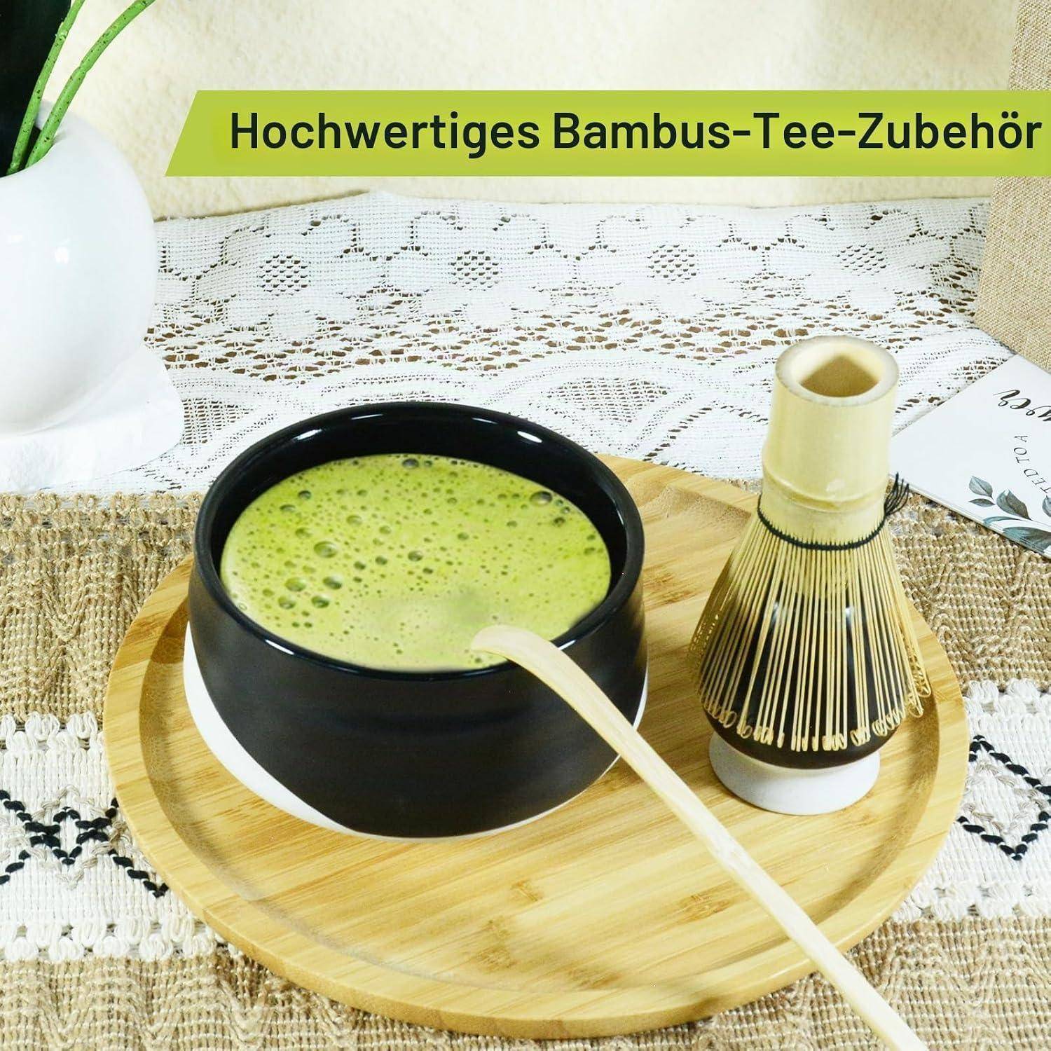 Matcha-Tee-Set mit schwarzer Schale grünem Tee, Bambusbesenund Löffel auf einem Bambusbrett; Banner liest „Hochwertiges Bambus-Tee-Zubehör"
