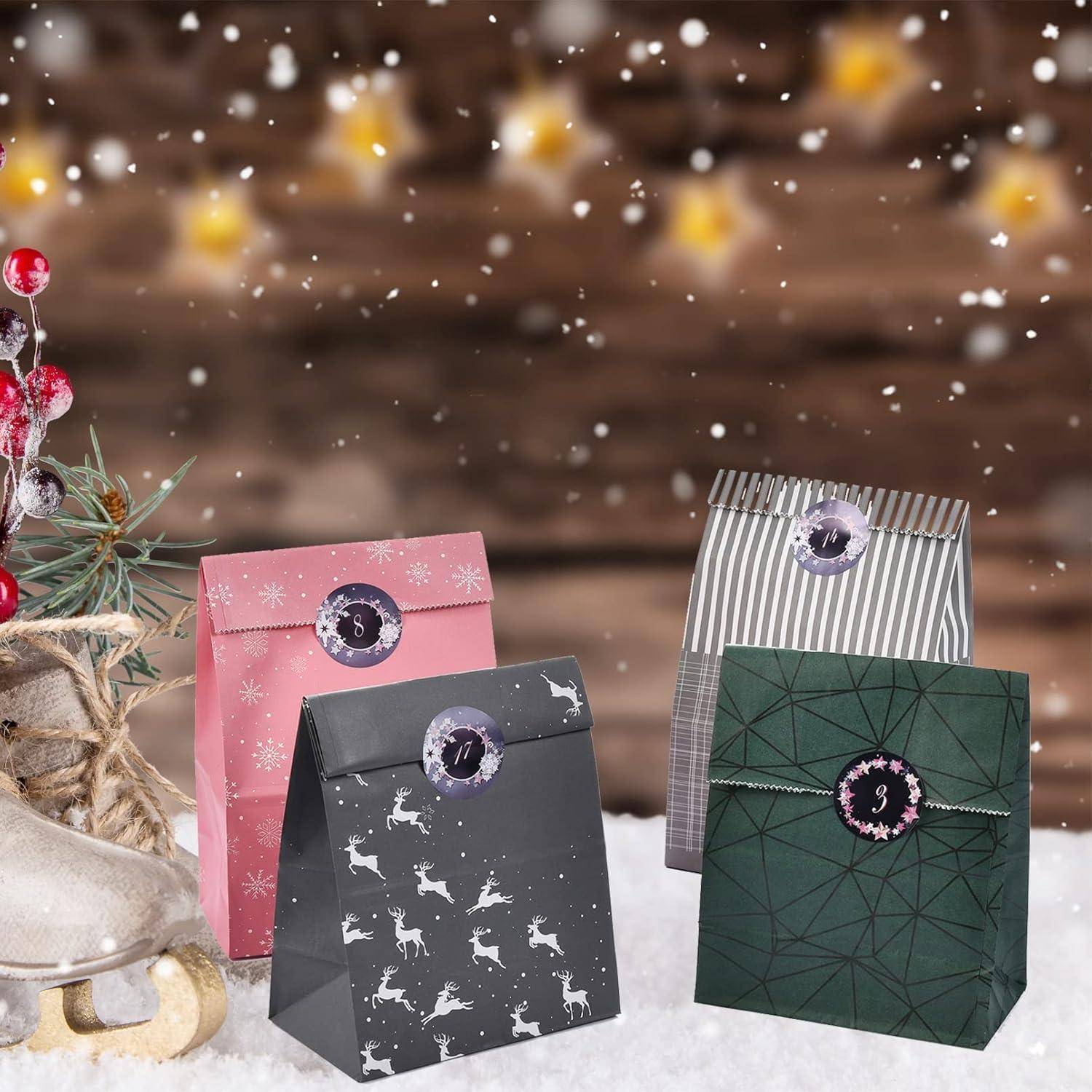 Vier dekorierte Geschenktüten mit nummerierten Ornamenten sitzen im Schnee, angeordnet wie ein Adventskalender auf einer winterlichen Feiertagsdekoration.