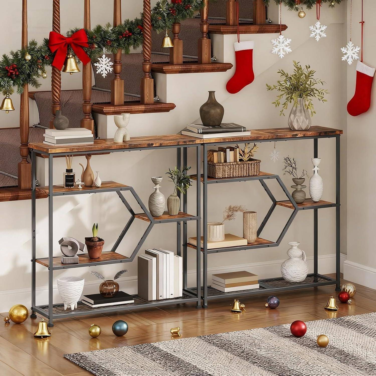 Weihnachtlich dekorierte Hausecke mit einer Treppe, Konsolentisch, Strümpfen, Schneeflocken und Regalen, auf denen Vasen, Bücher und Ornamente stehen.
