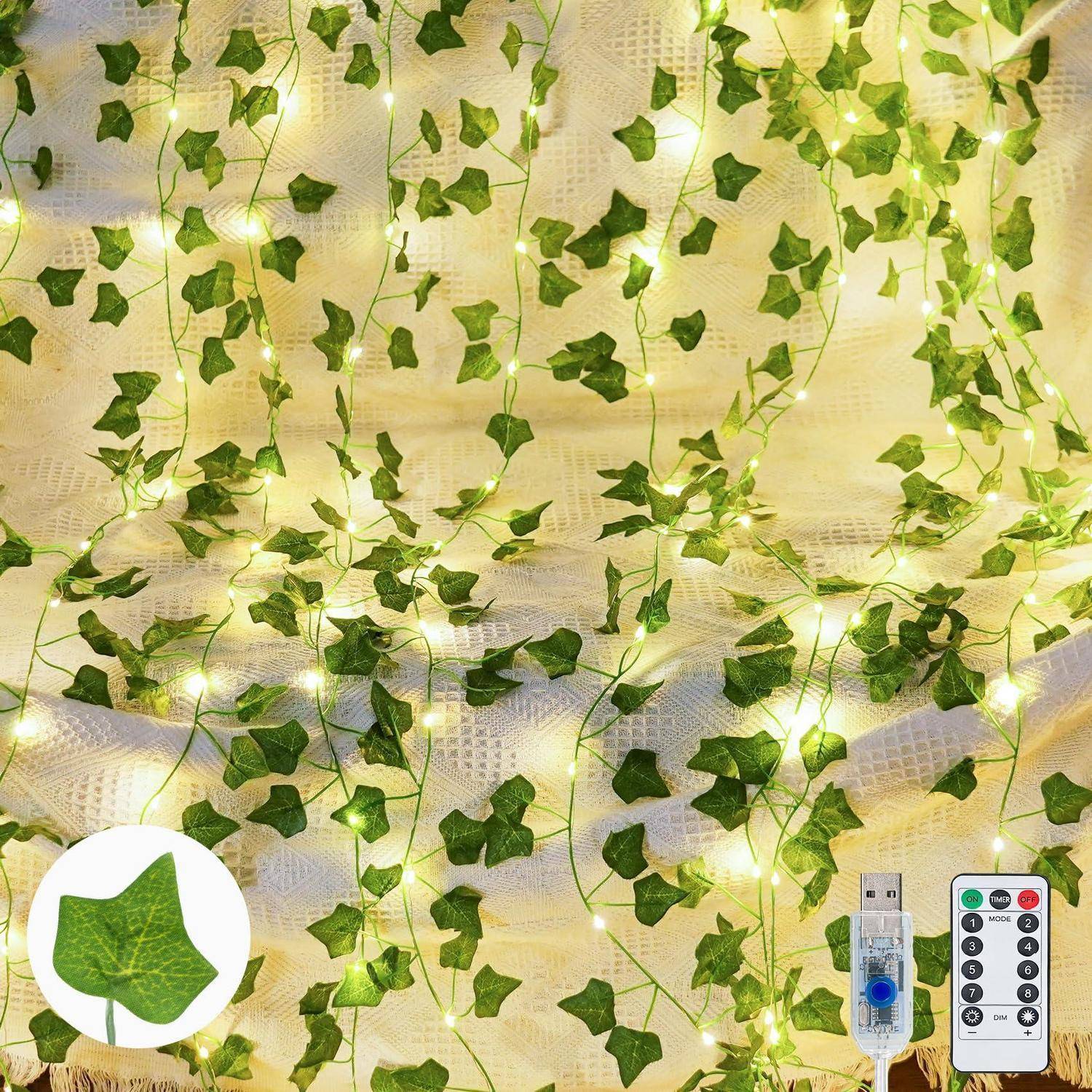 Lichterketten, die durch grüne Efeu-Ranken auf einem hellenen Stoffhintergrund verwoben sind, mit Fernbedienung und USB-Controller unten rechts dargestellt.