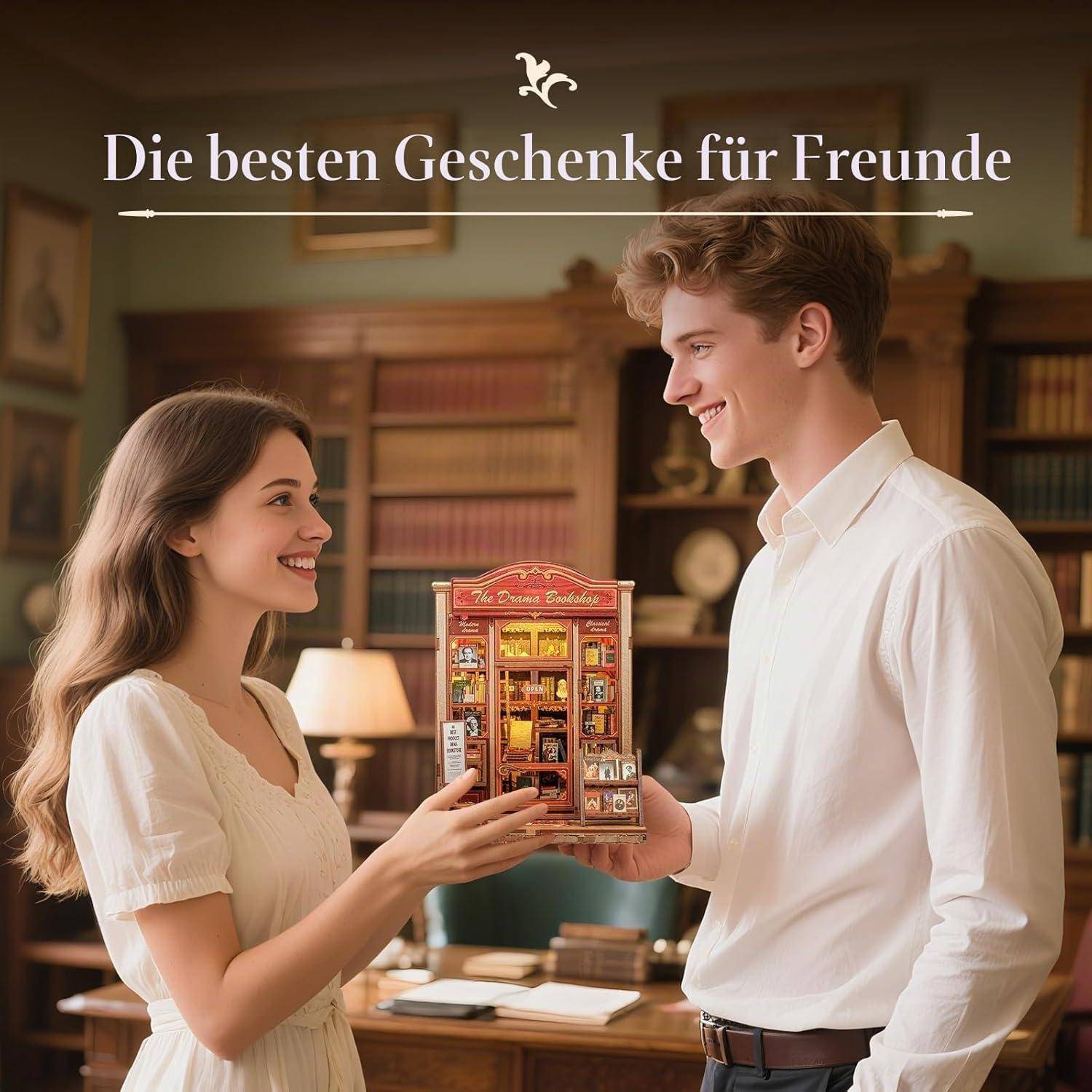 Lächelnder junger Mann und Frau tauschen eine Miniatur-Geschenkbox aus, mit deutschem Text „Die besten Geschenke für Freunde